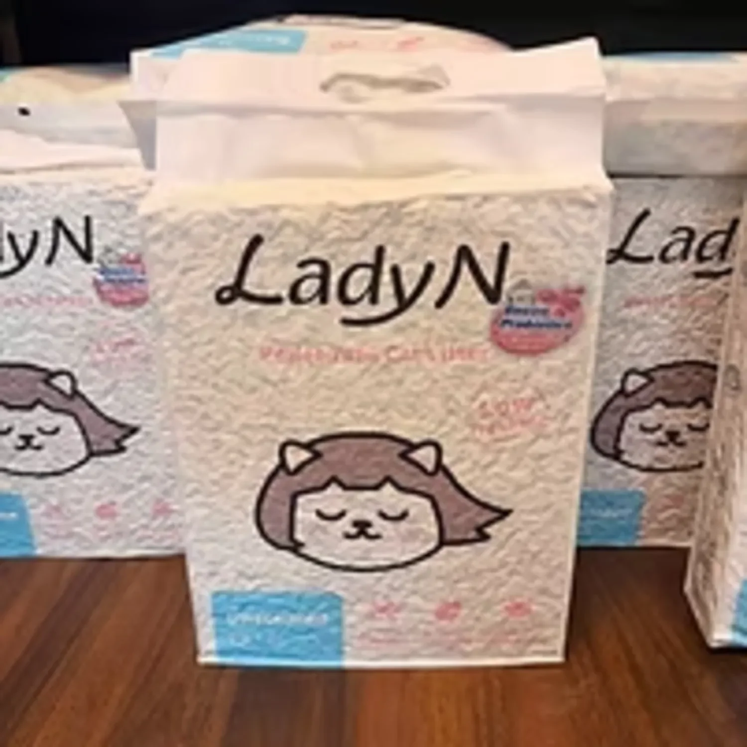 A pack of LadyN facial tissues with a cartoon girl's face on the packaging, placed on a wooden surface.