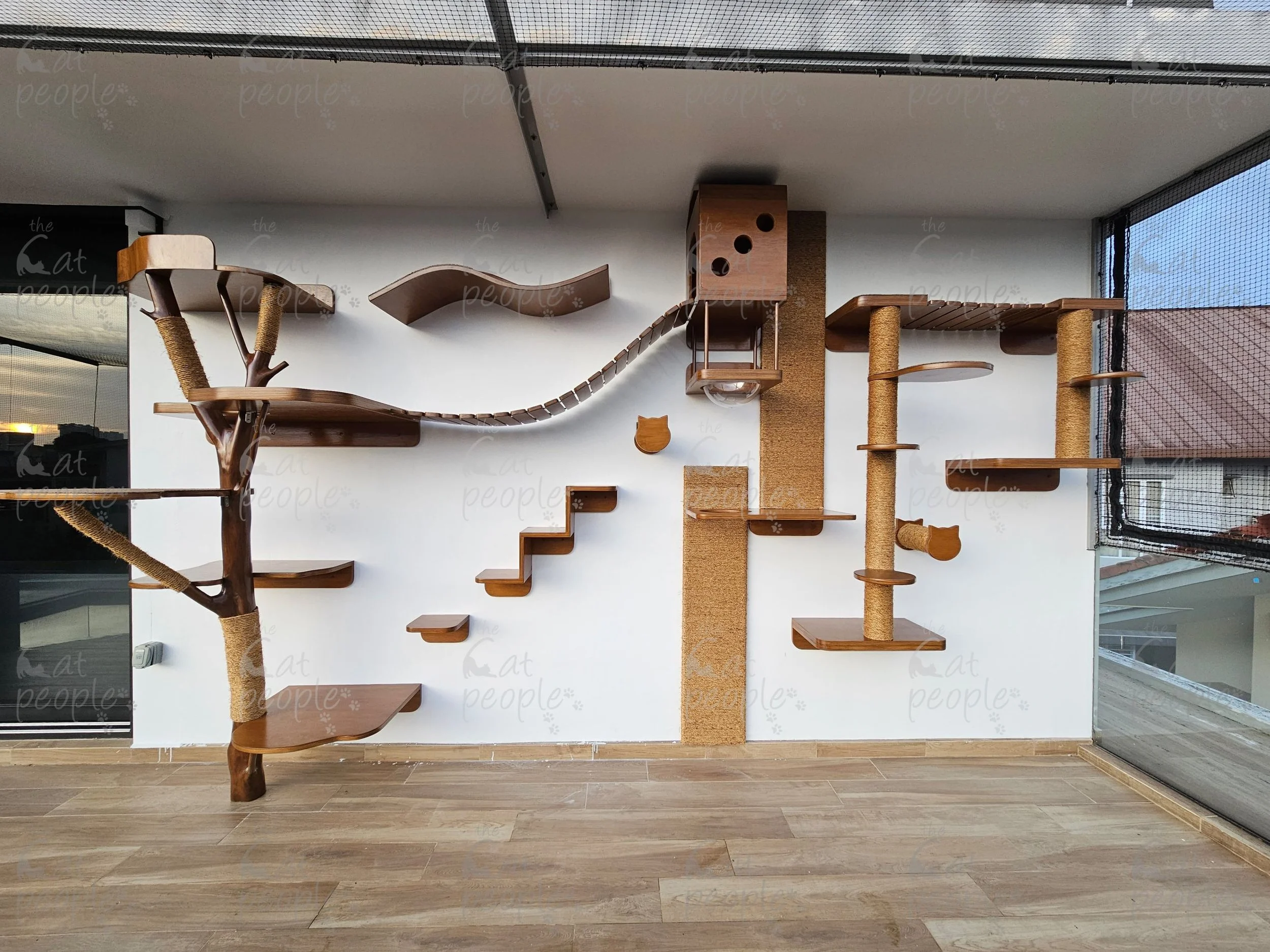 Indoor pet climbing structure with multiple platforms, logs, and hiding spots made of wood and sisal rope.