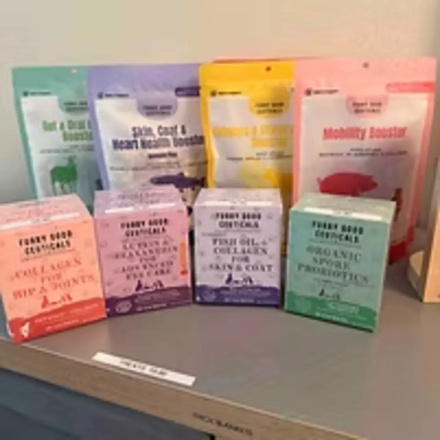 Display of various boxes of pet food, including Holistic Select, and other brands, arranged on a shelf in a pet store.