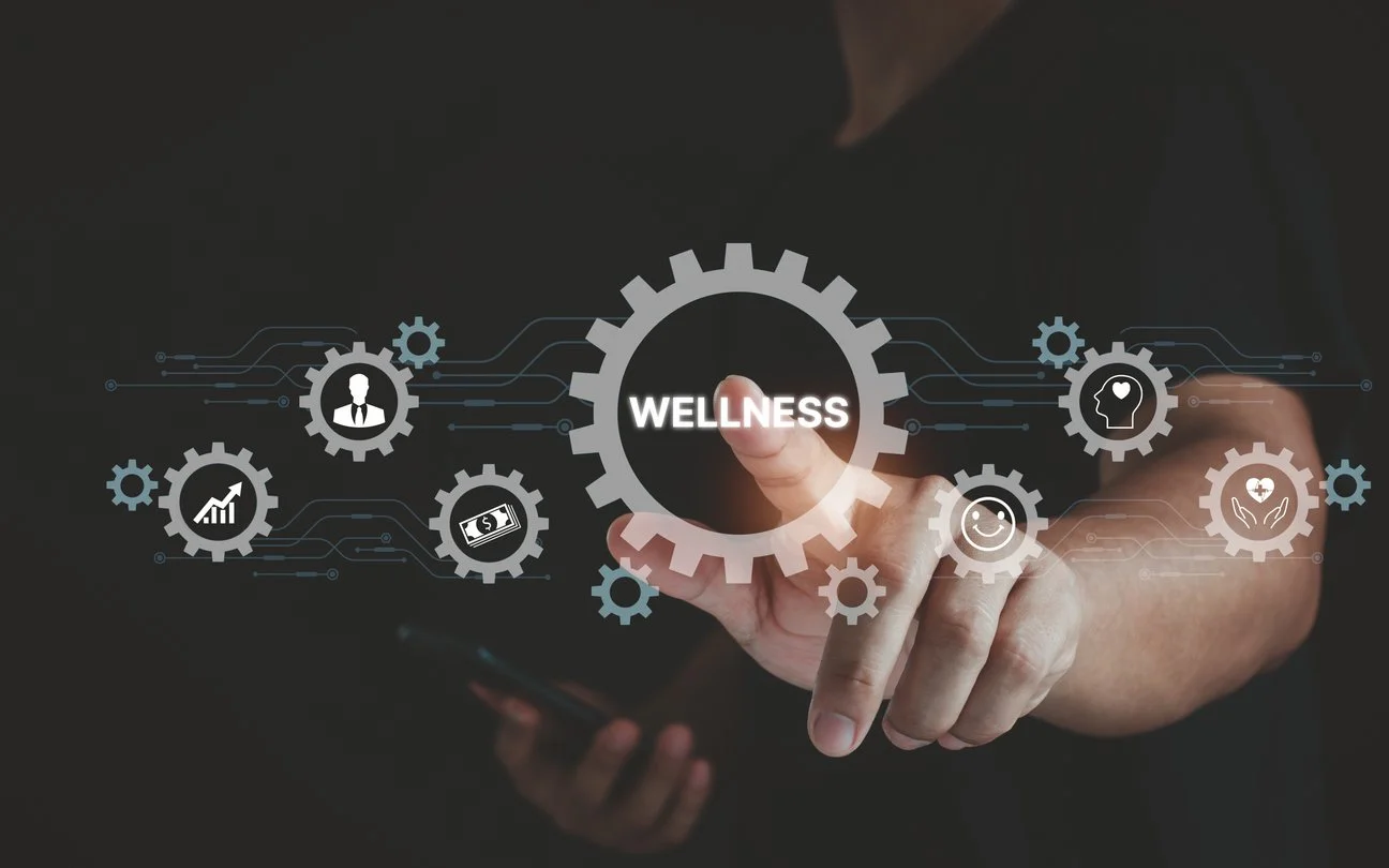 A person touches a virtual interface with icons representing wellness, health, and happiness, featuring gear and human profile symbols.