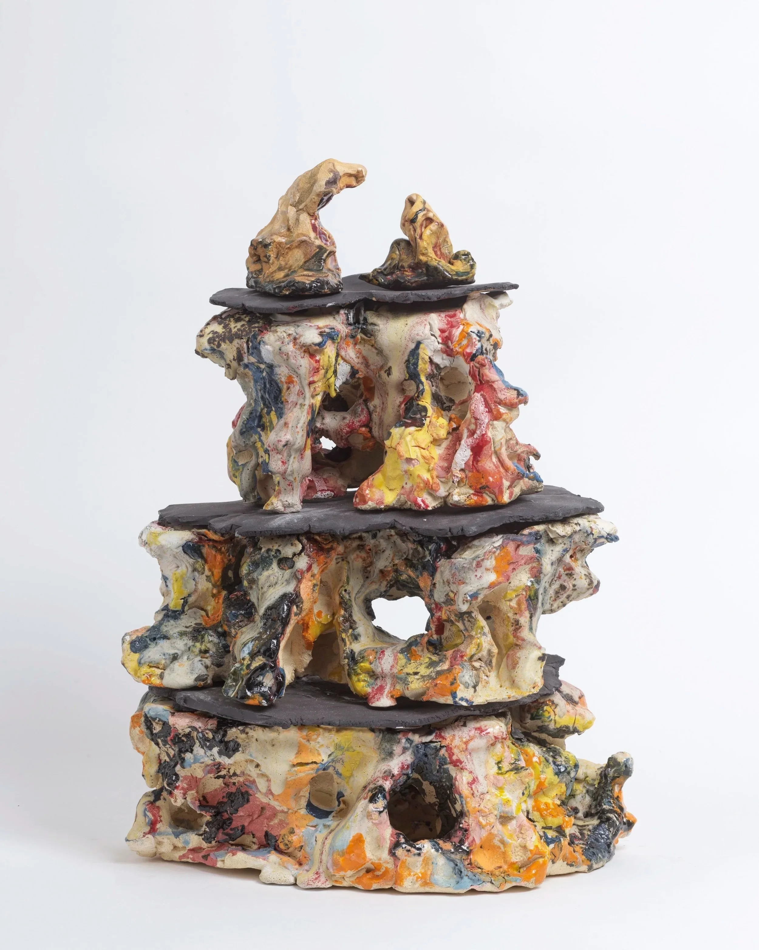 Multicolored abstract sculpture with layered, textured, irregular shapes resembling a fantasy landscape or organic forms stacked on top of each other.