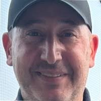 Close-up of a smiling man wearing a cap