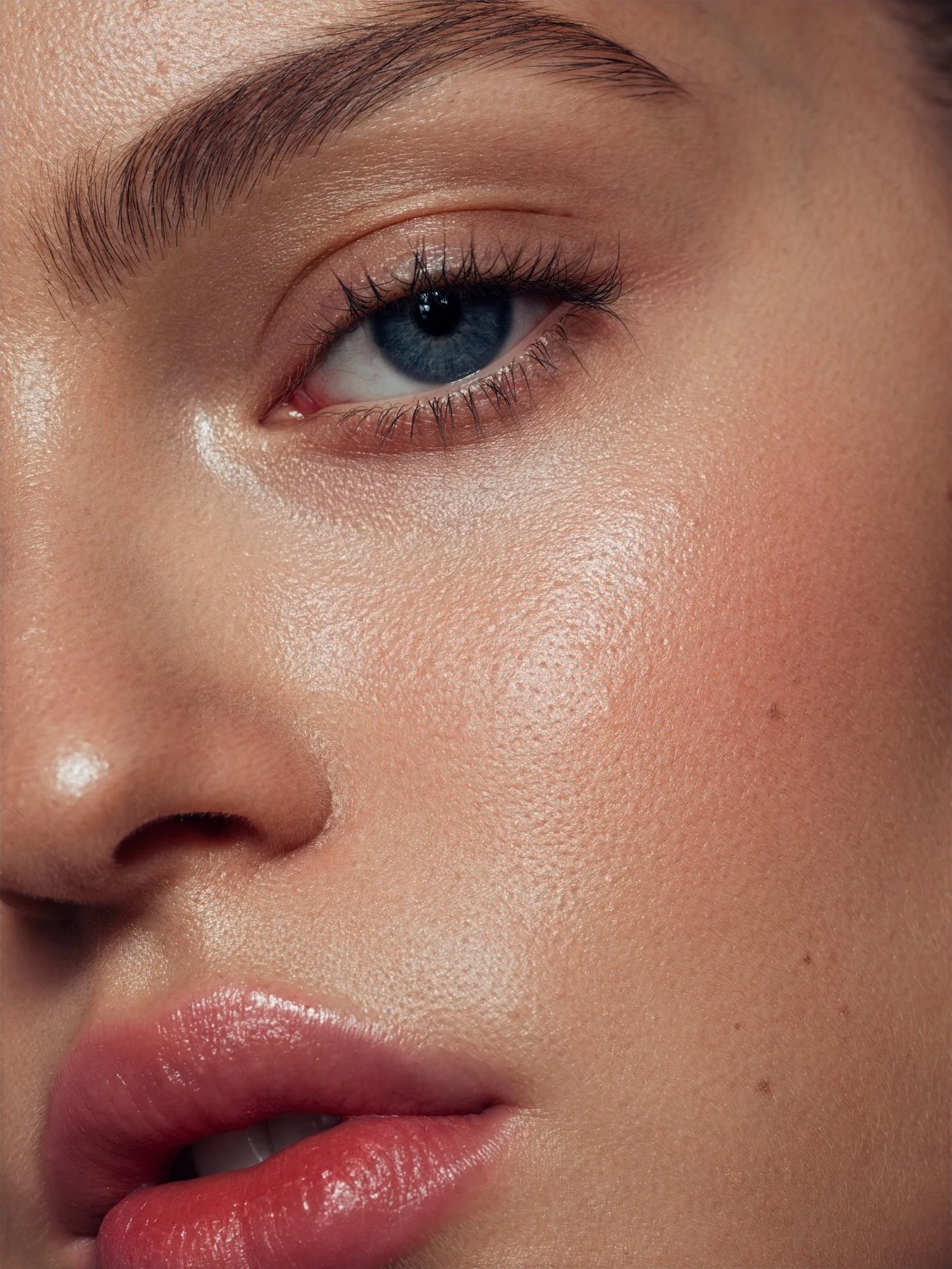Close-up portrait of a woman with glowing skin, defined lashes and natural beauty.