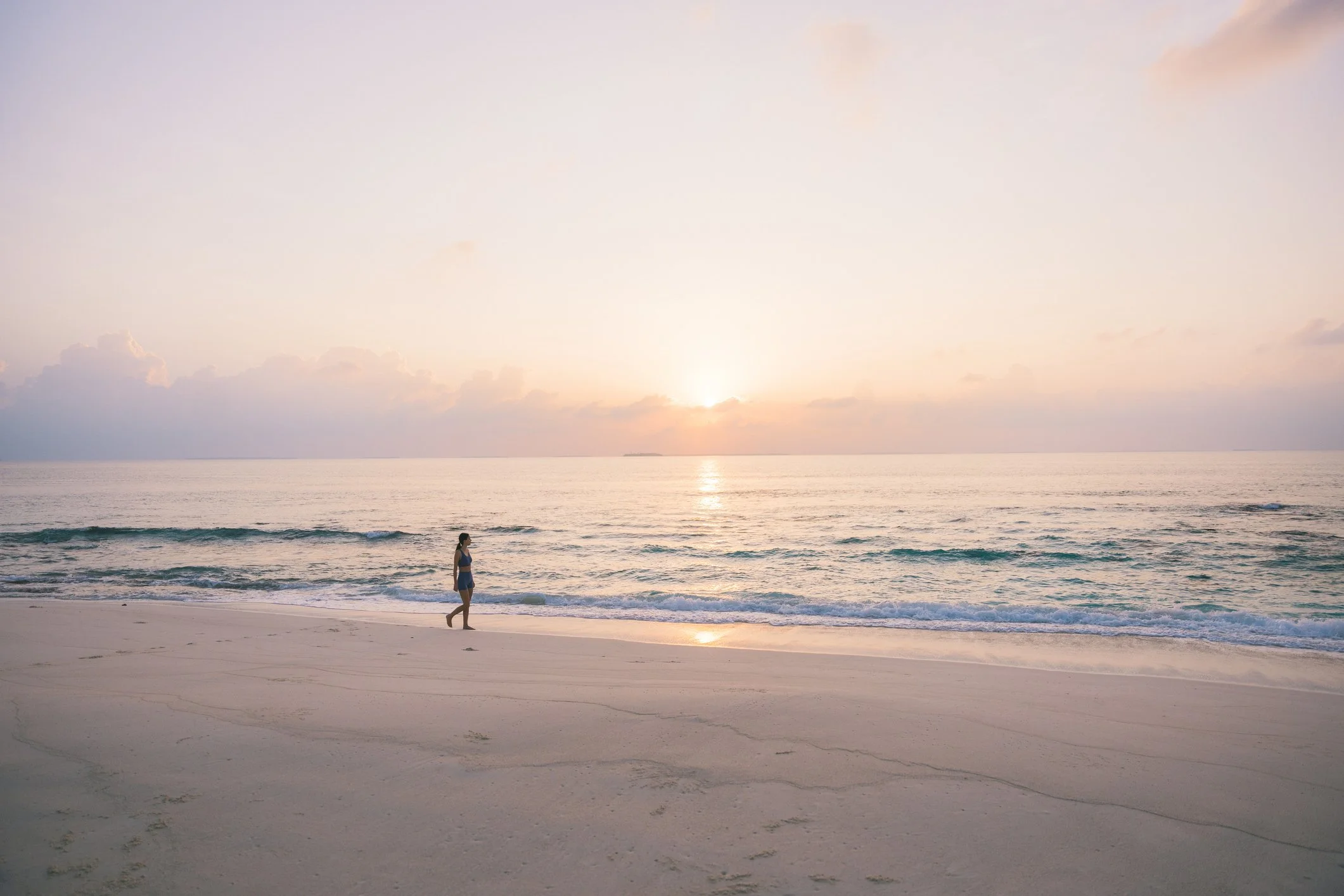 Feeling refreshed and recharged while enjoying a peaceful walk along the beach at sunset.