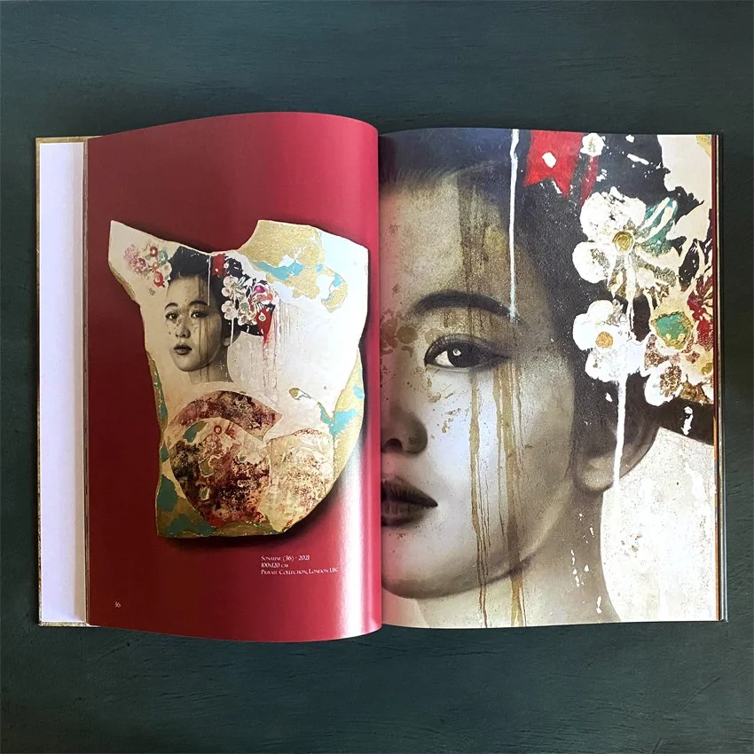 Open art book displaying a collage with a woman's face and a smaller portrait of a woman in traditional Asian attire, with floral and abstract elements on a red background.