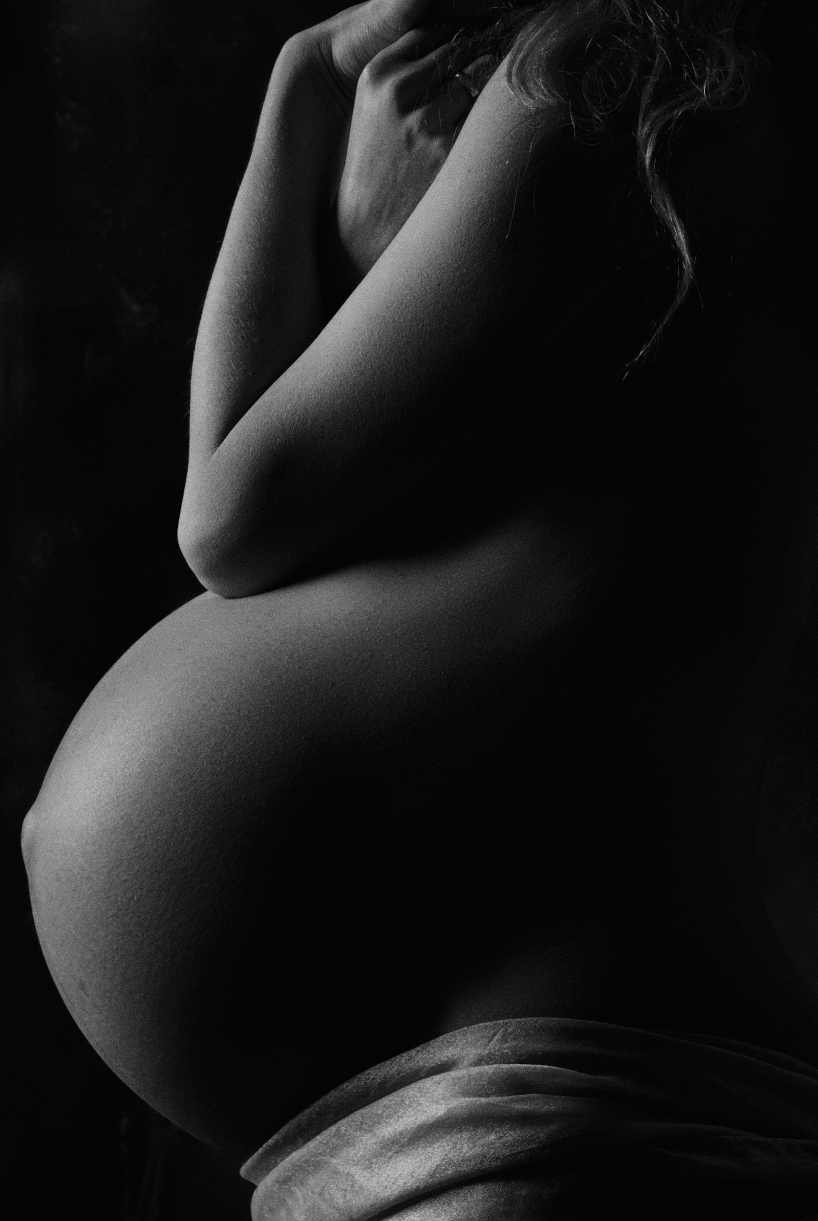 Black and white photograph of a pregnant woman's baby bump