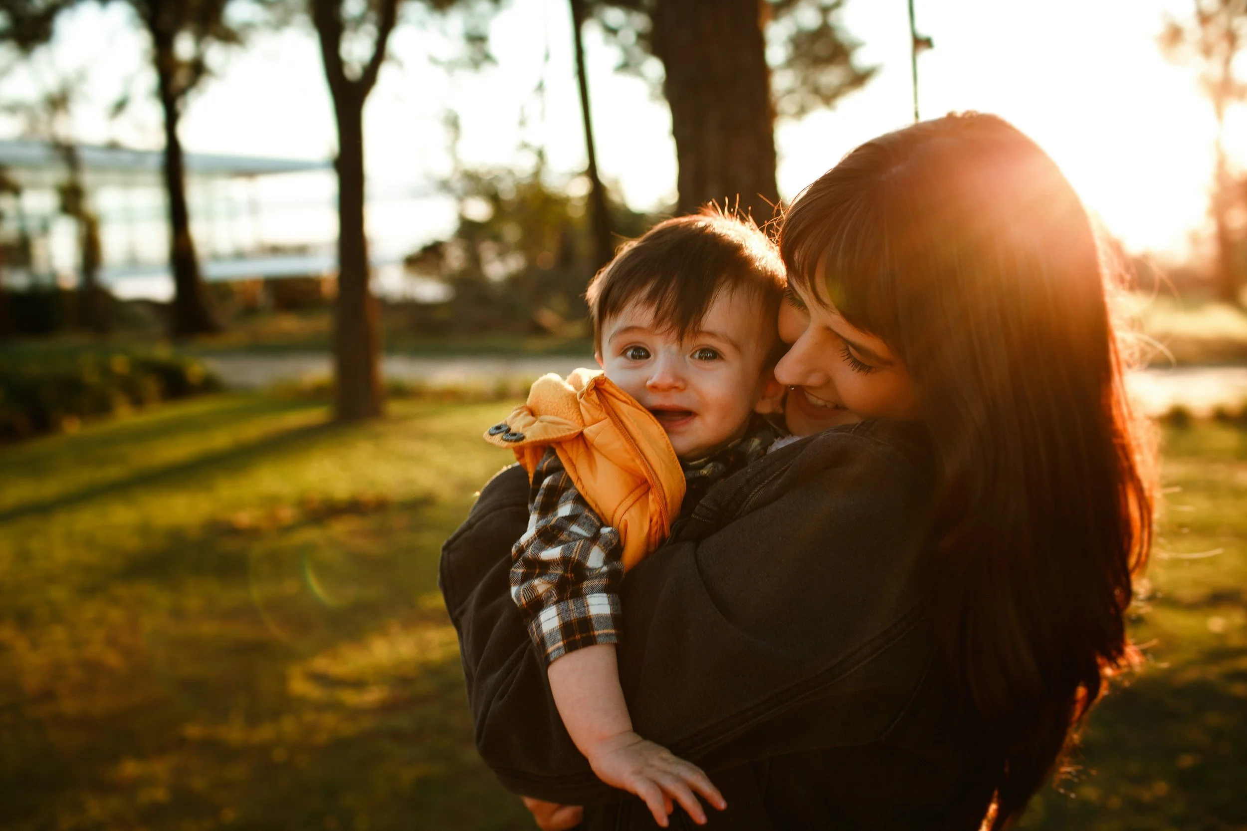 Mother cuddling her toddler in the sunshine
