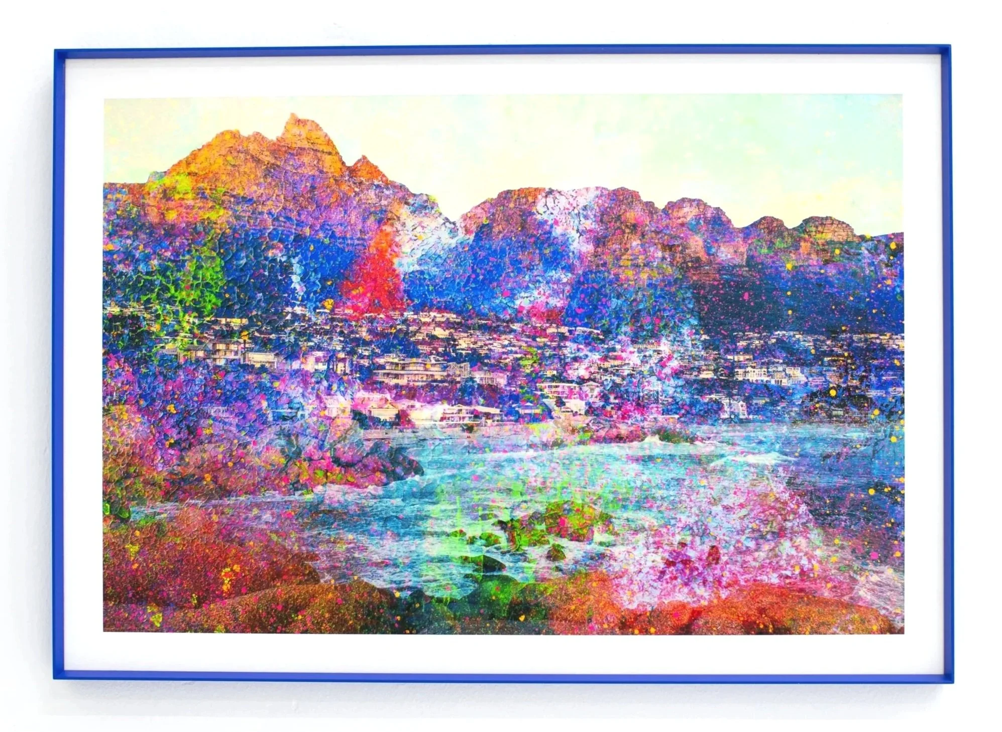 Colorful abstract mountain landscape painting framed in blue, mounted on a white wall.