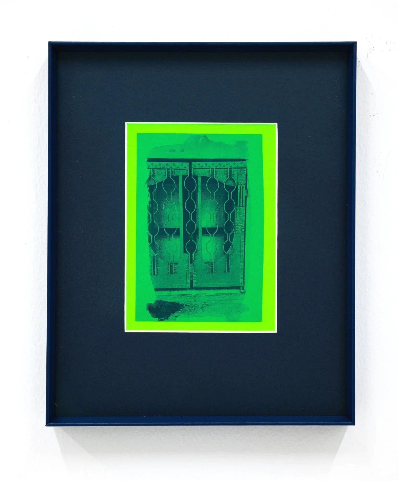 An art piece in a blue shadow box with a neon green border, depicting a doorway.