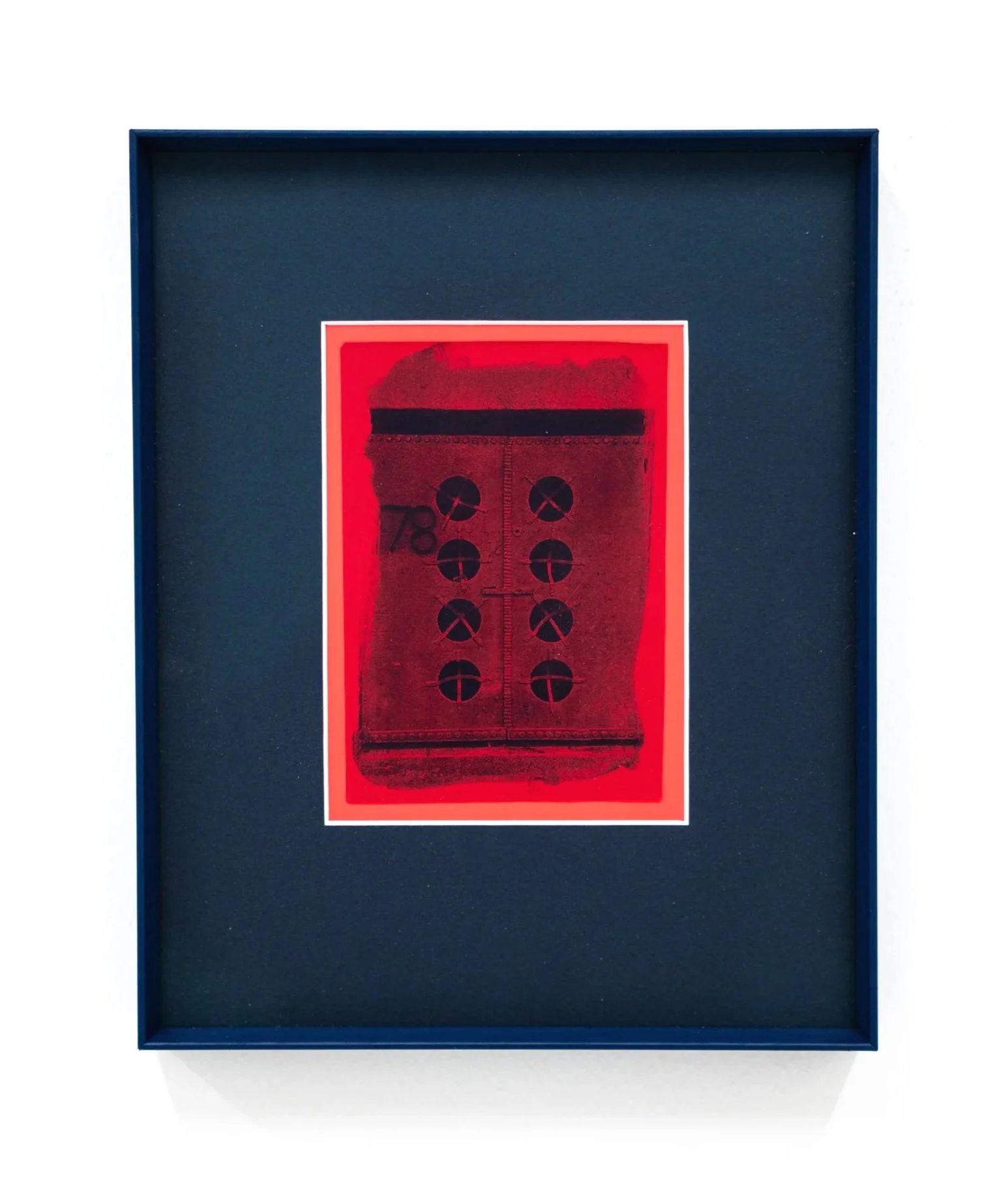 Framed artwork of a red and black design resembling a vintage device or keypad with buttons.