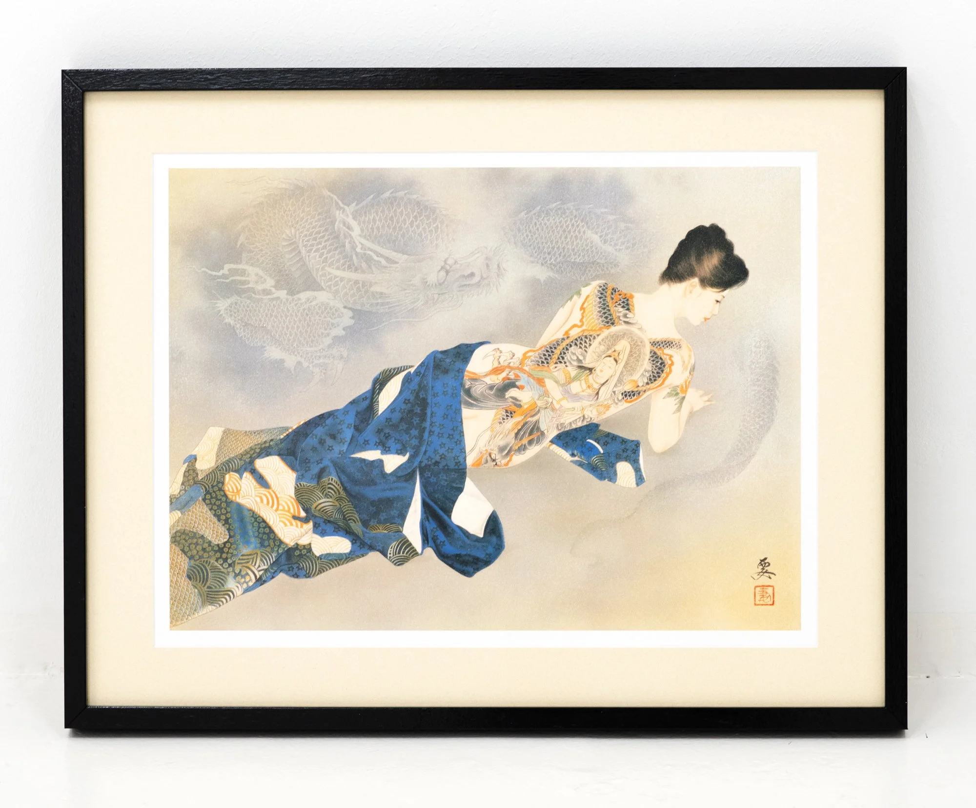Framed Japanese-style painting of a woman in traditional kimono with clouds and a dragon in the background, hanging on a white wall.
