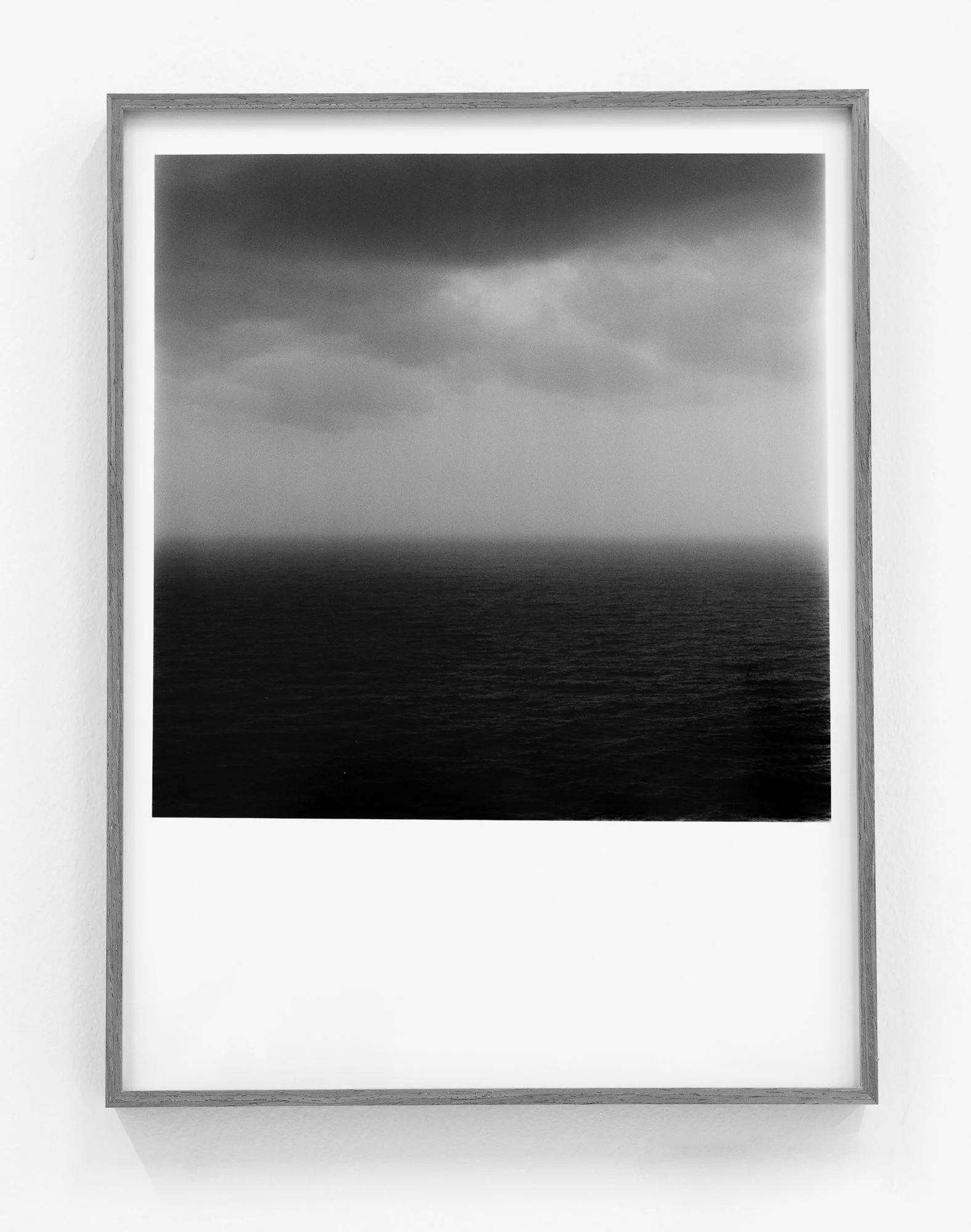 Black and white photo of a seascape with dark storm clouds over the ocean.