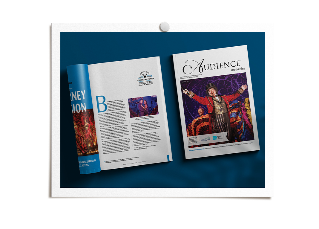 Audience Magazine on a blue surface, features a performer in colorful costume performing in a Broadway show.
