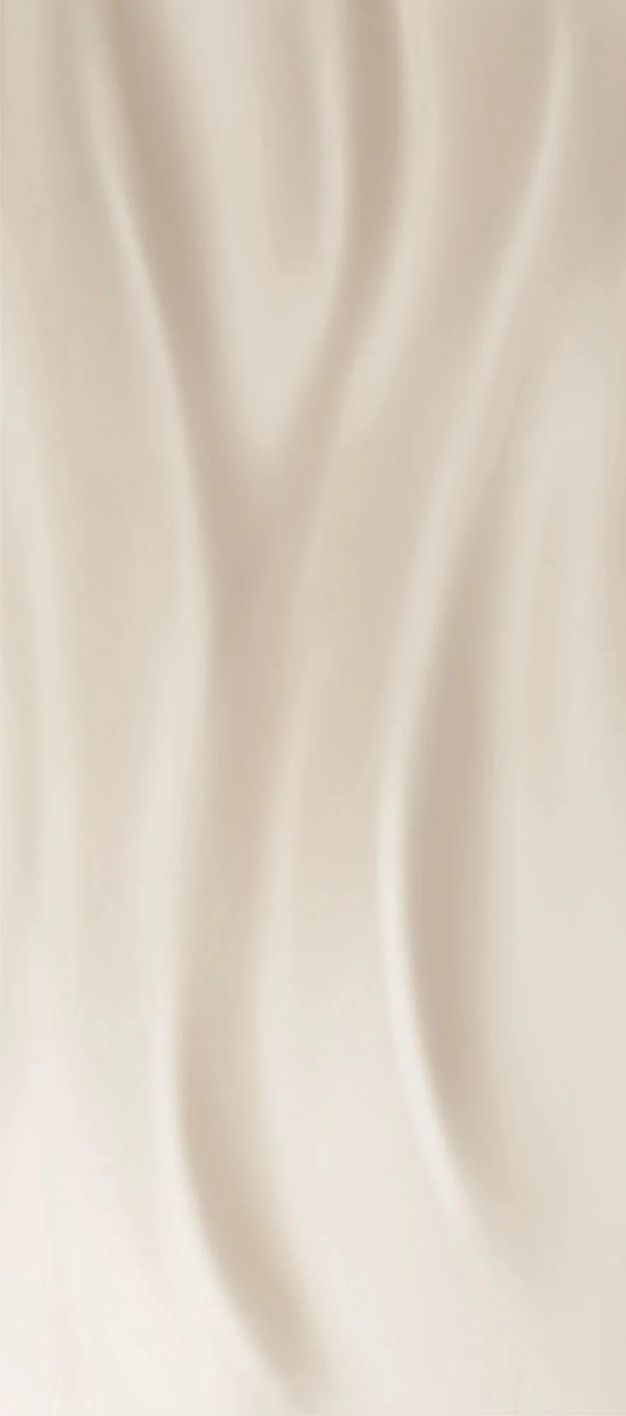 Close-up of cream-colored fabric with soft folds.