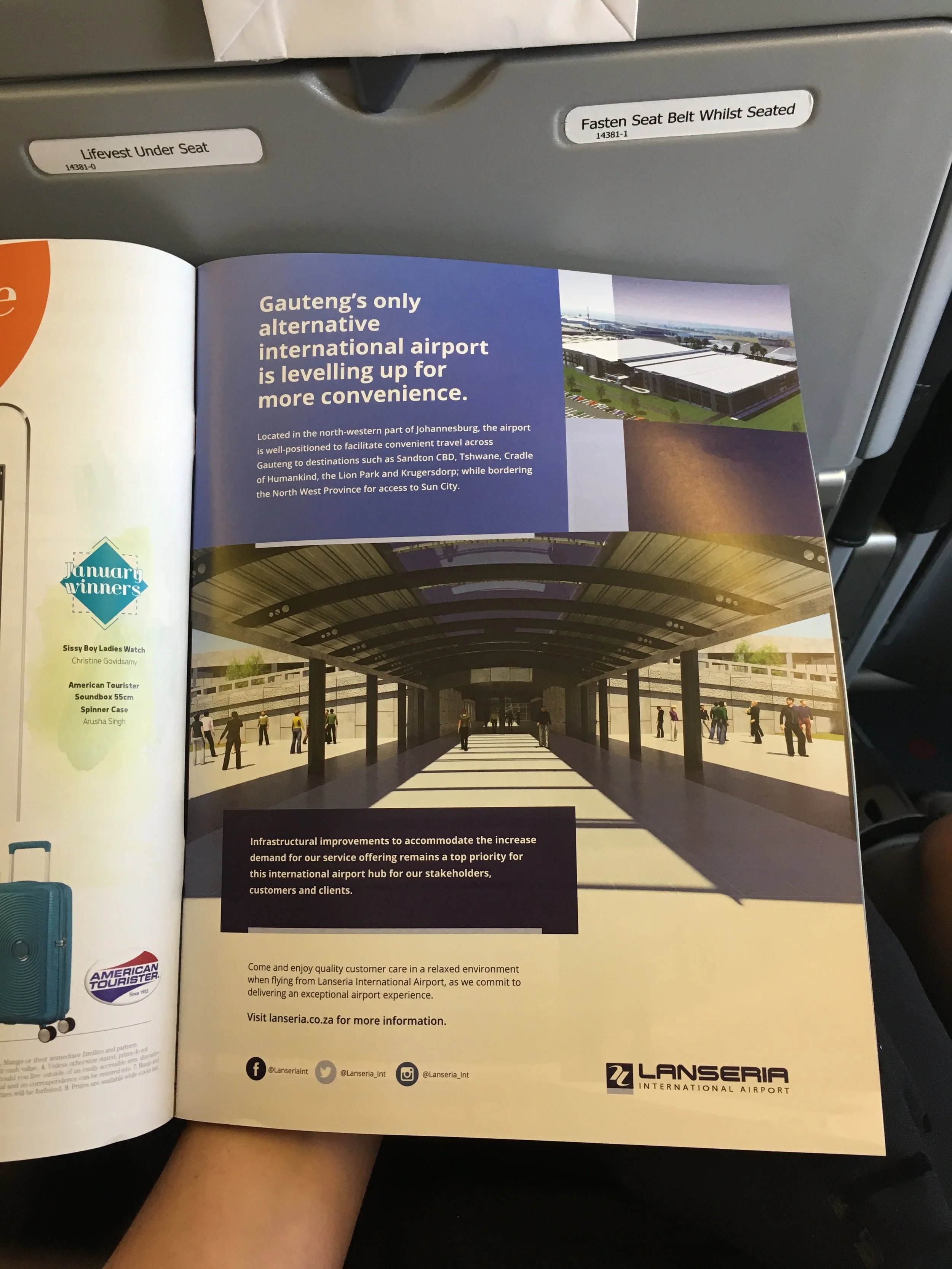 A pamphlet advertising Lanseria International Airport, showing a modern airport terminal with a covered walkway and passengers walking inside. The pamphlet highlights infrastructure improvements and convenience, and includes logos for American Tourister and Lanseria.