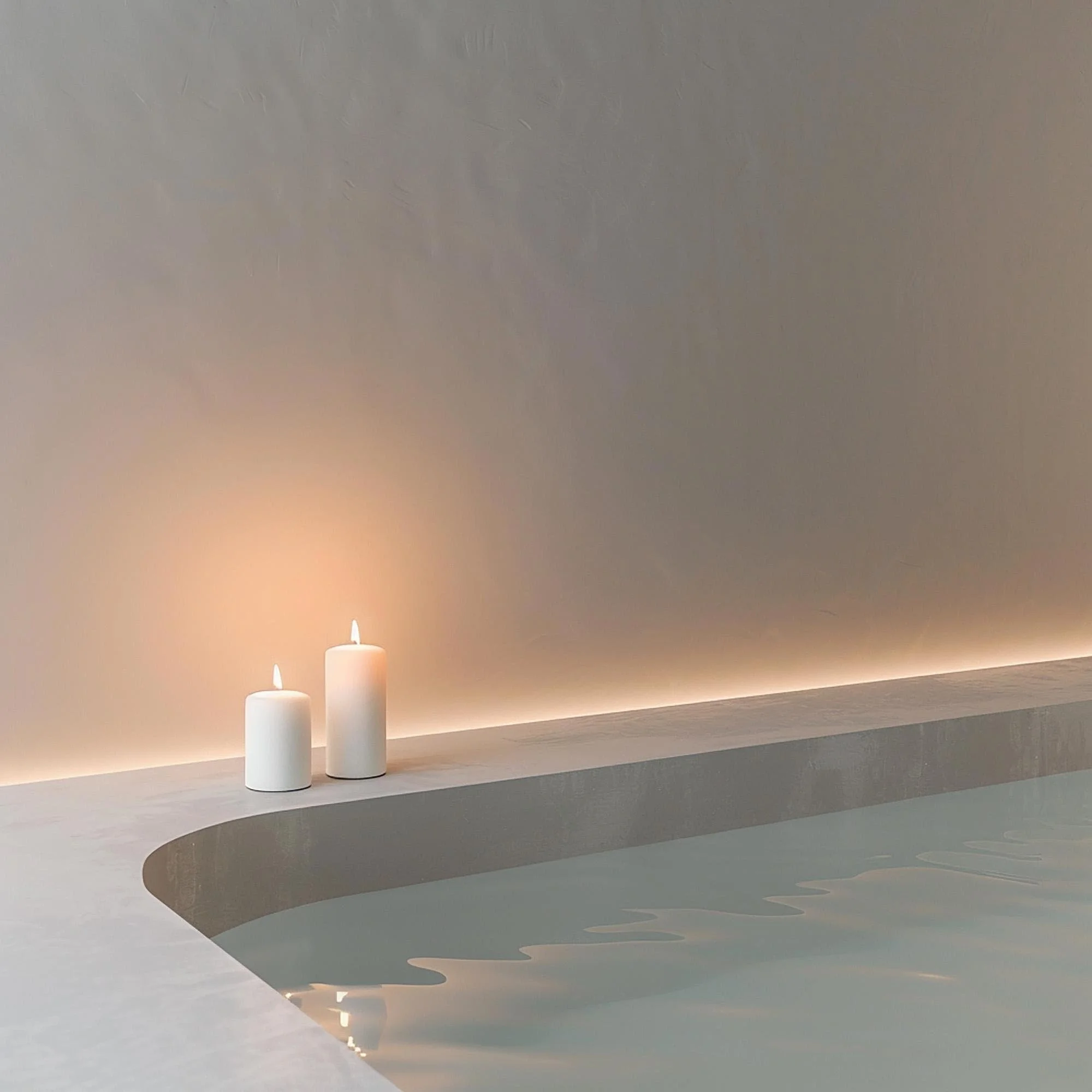 Three white candles on a white surface against a beige wall, with shadows cast on the wall.