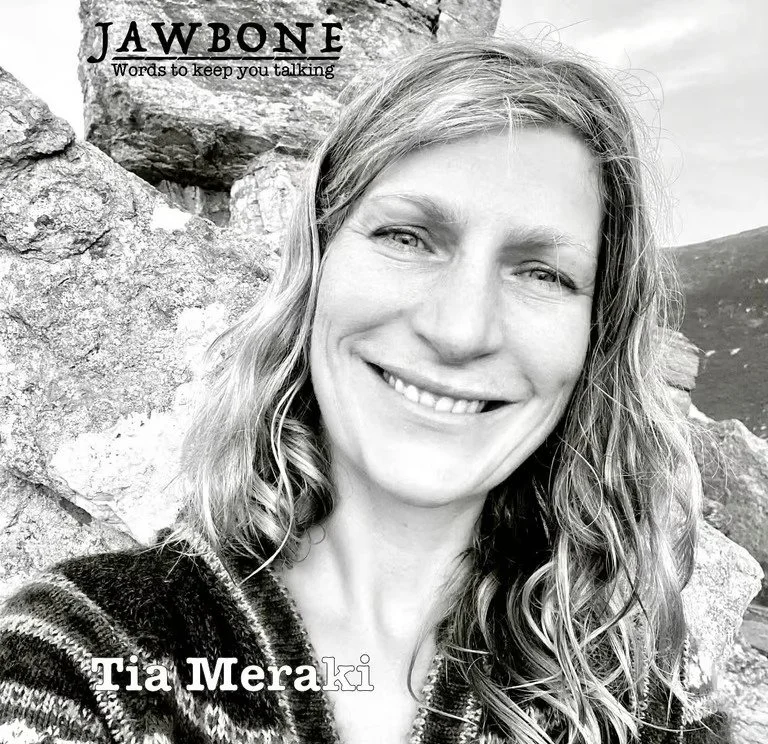 A black and white photo of a smiling woman with wavy hair outdoors, with rocks and a cloudy sky in the background. Text on the image reads 'JAWBONE Words to keep you talking' and 'Tia Meraki'.