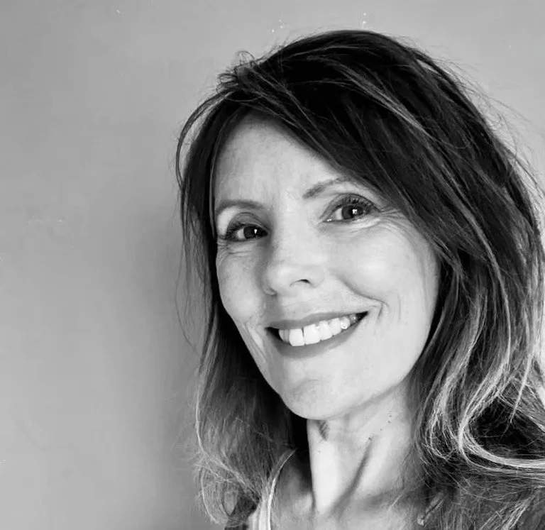 Black and white photo of a woman with shoulder-length hair smiling at the camera.