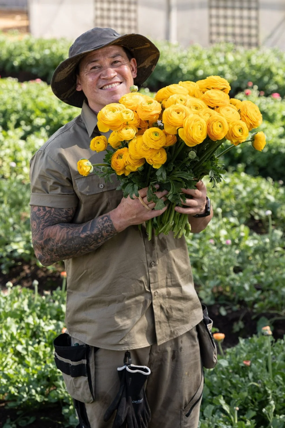 Rob holding a bunch of yellow ranunculus grown at Blume Estate flower farm