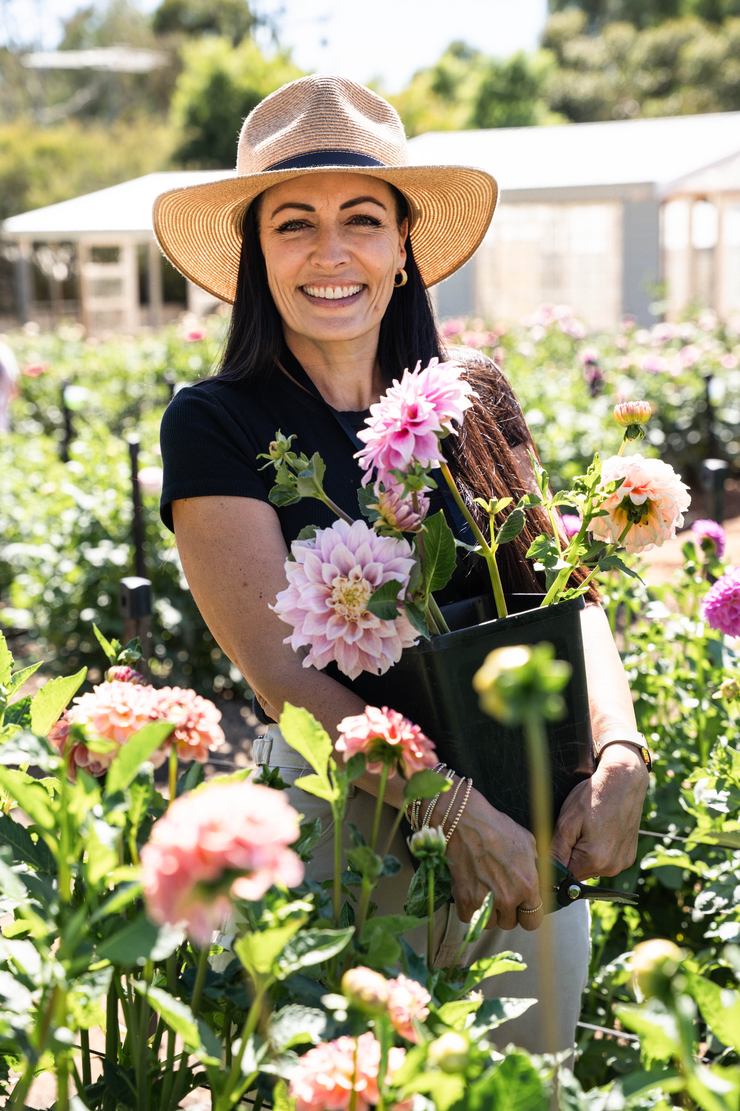 Blume Retreat attendee holding a bucket of freshly harvested dahlias
