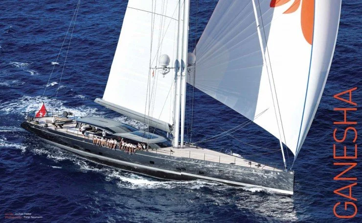 Ein luxuriöses Segelschiff mit weißen Segeln auf offenem Meer.