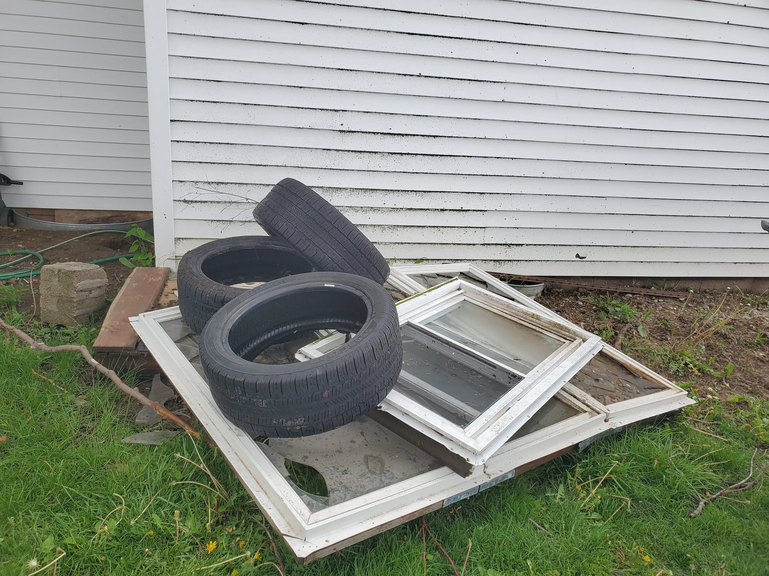 Junk removal pile with tires, old windows, and pallets hauled by Junk Solutions LLC in Bluffton, Indiana