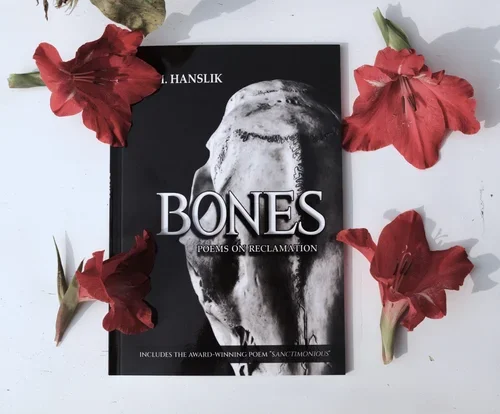 A black book titled 'Bones' surrounded by red flowers, with the subtitle 'Poems on Reclamation' and the author's name 'J. Hanslik' on a white background.