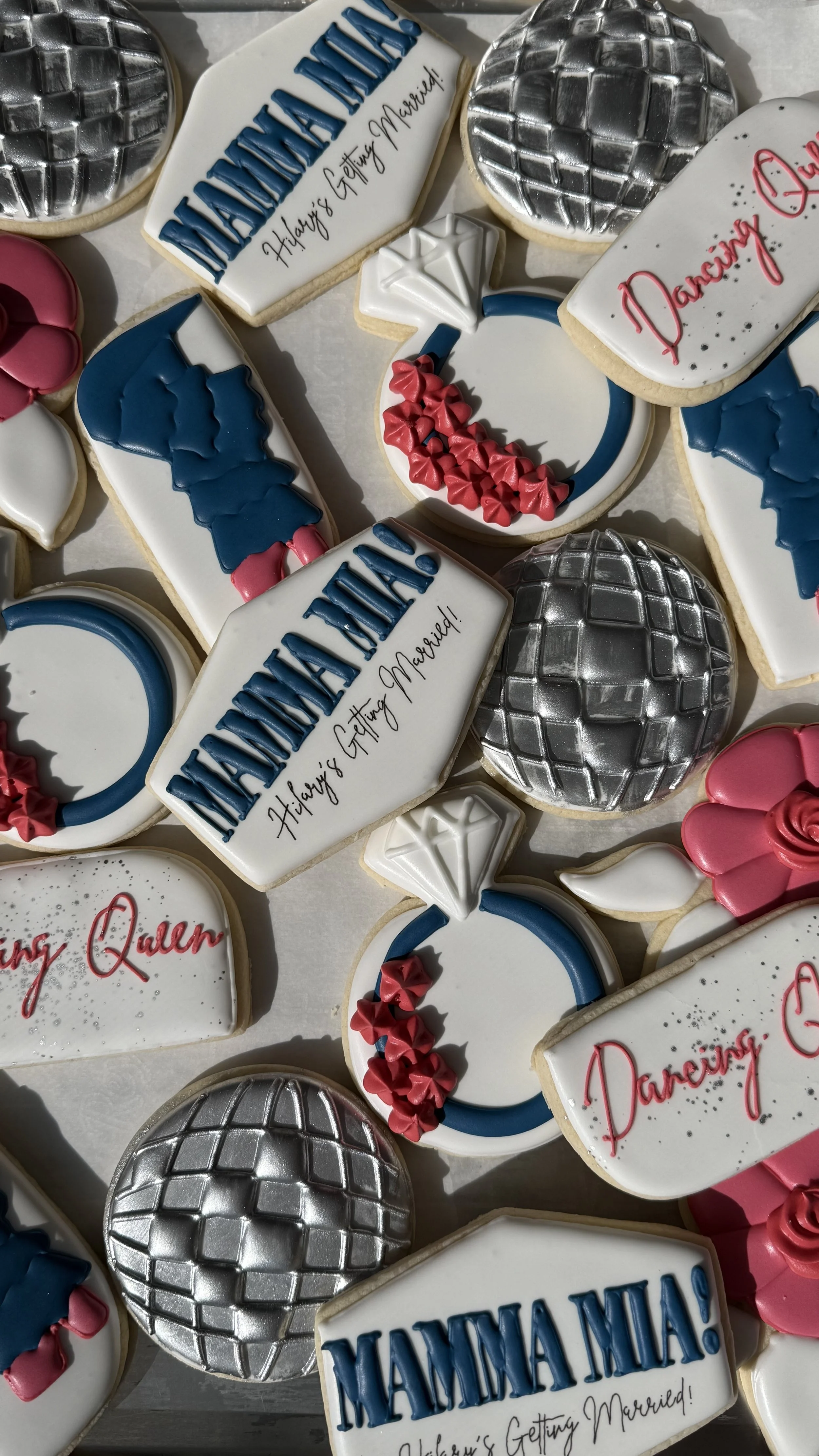 Assorted decorated cookies celebrating a marriage proposal, with messages like 'Happily Getting Married!', 'YAMAMAMA!', and 'Darling!'. Some cookies feature designs like a disco ball, a diamond ring, a blue and pink heart, and red bows.