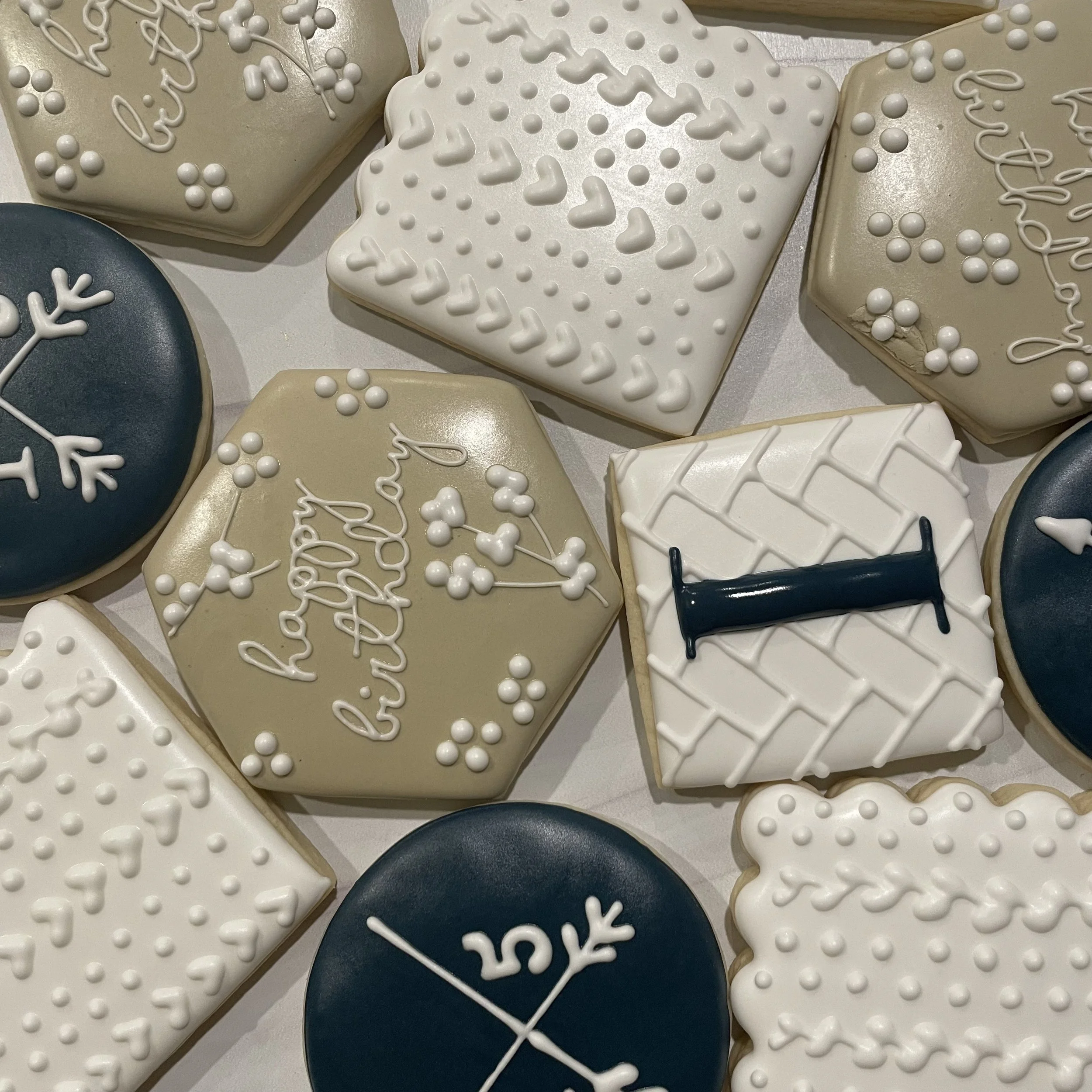 A collection of decorated cookies, some shaped like hearts and some with holiday-themed icing and sprinkles.