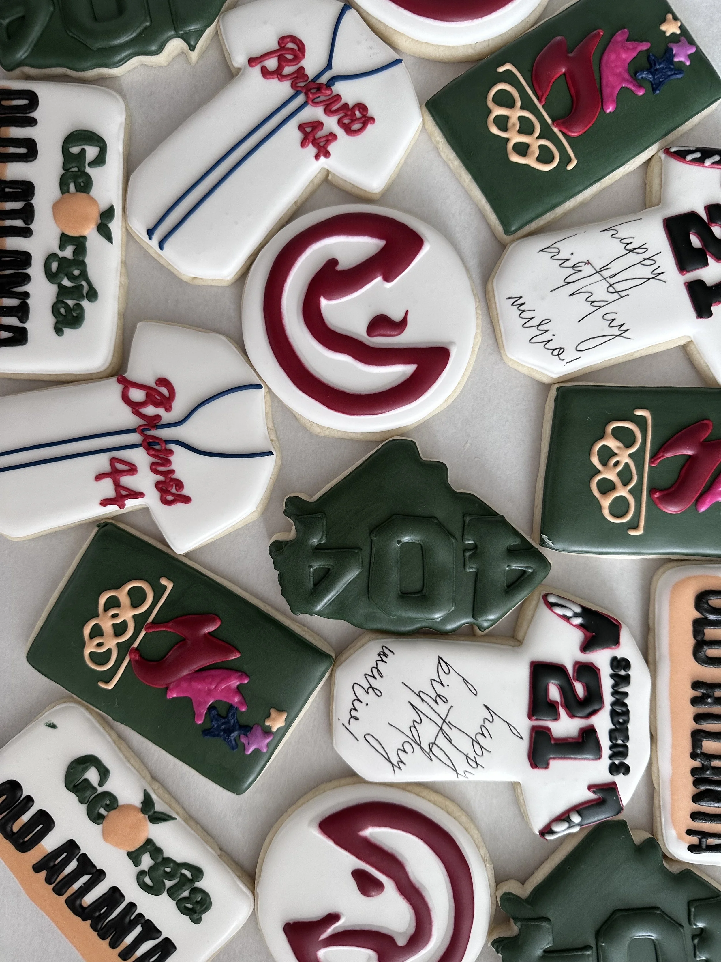 Decorated cookies celebrating a 44th birthday, featuring various designs including a birthday handshake, a 44th birthday message, and anniversary-themed cookies with hearts, stars, and friendship messages.
