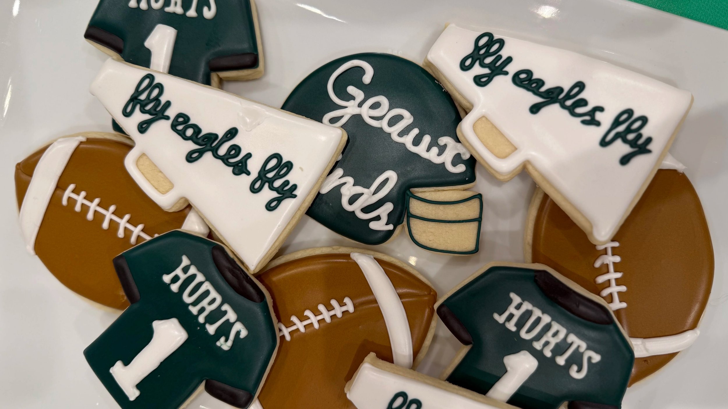 Cookies decorated with football and school-themed designs, some with the words "Go Eagles."