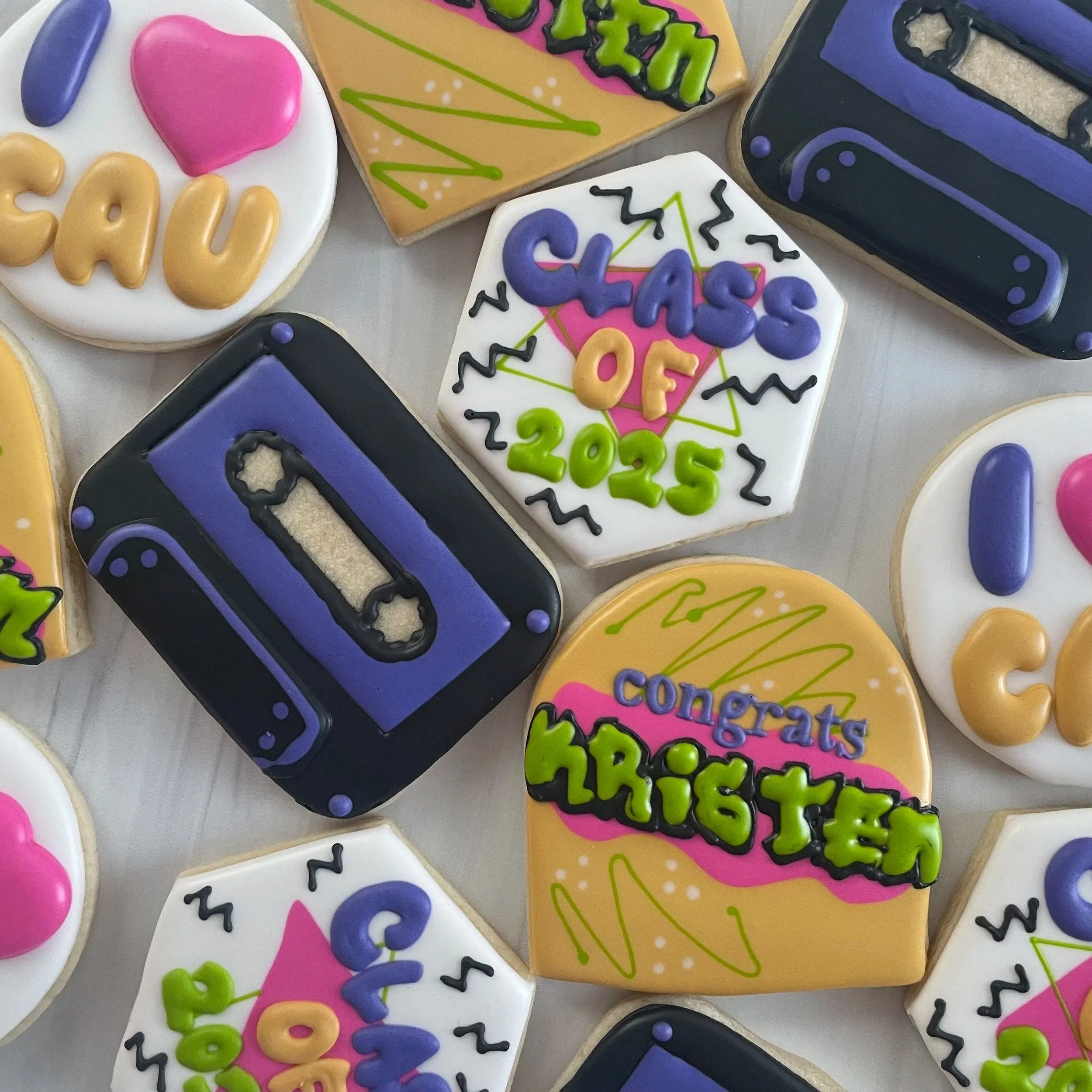 Decorated sugar cookies with colorful icing and text celebrating the new year 2025, with various designs including hearts, birthday cakes, and abstract patterns.