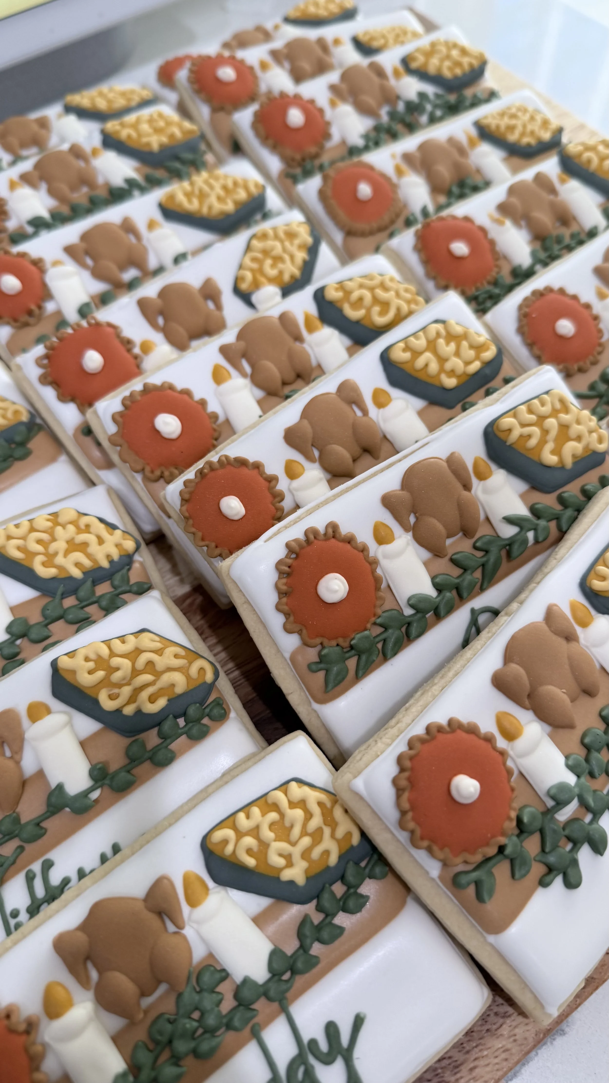 Close-up of decorated cookies with farm-themed designs, including animals, barns, and plants, arranged on a tray.