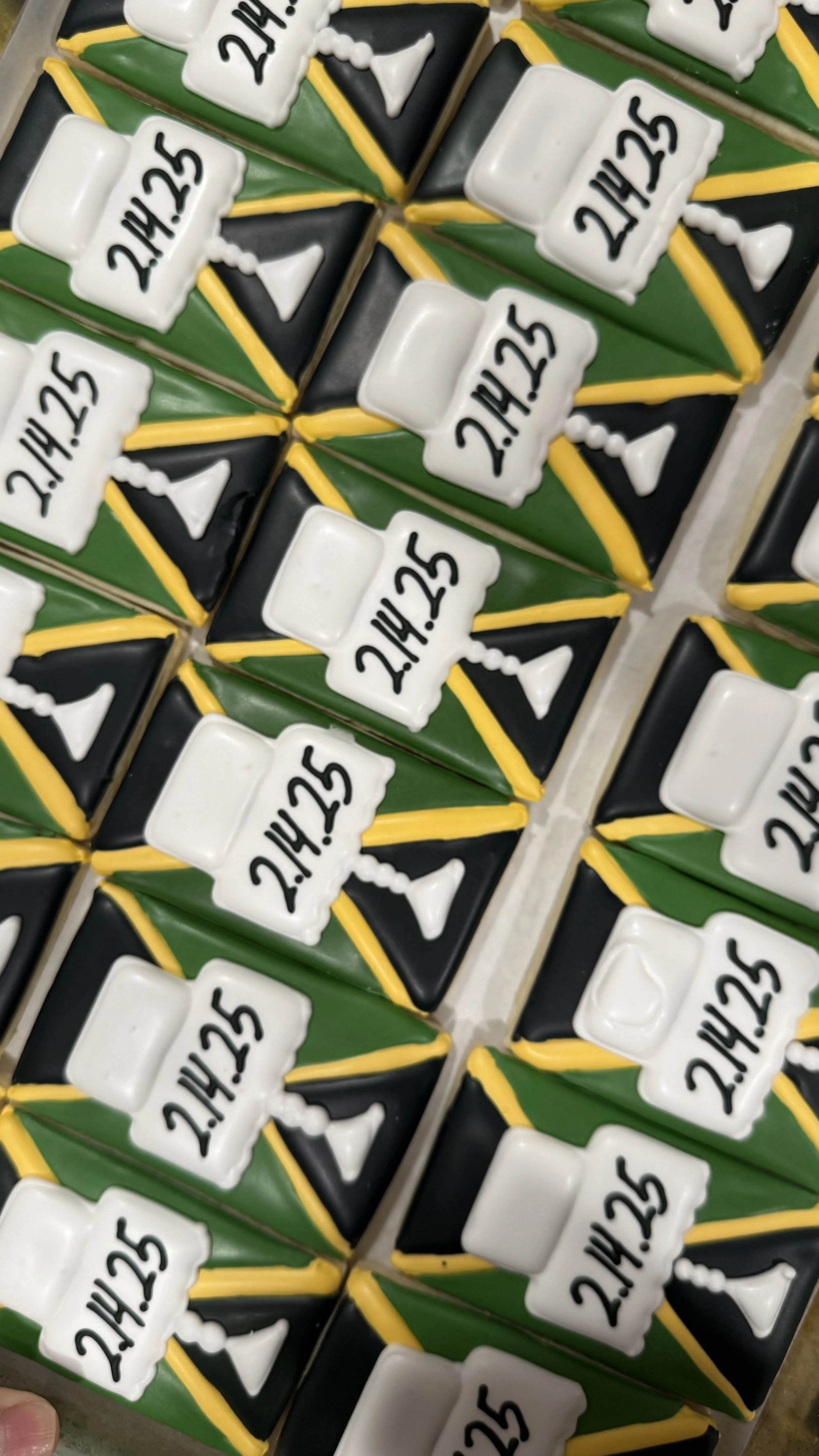 Celebration cake decorated with green, black, and yellow icing, featuring white bingo number markers with black numbers reading '21/25' and small white bunting flags.