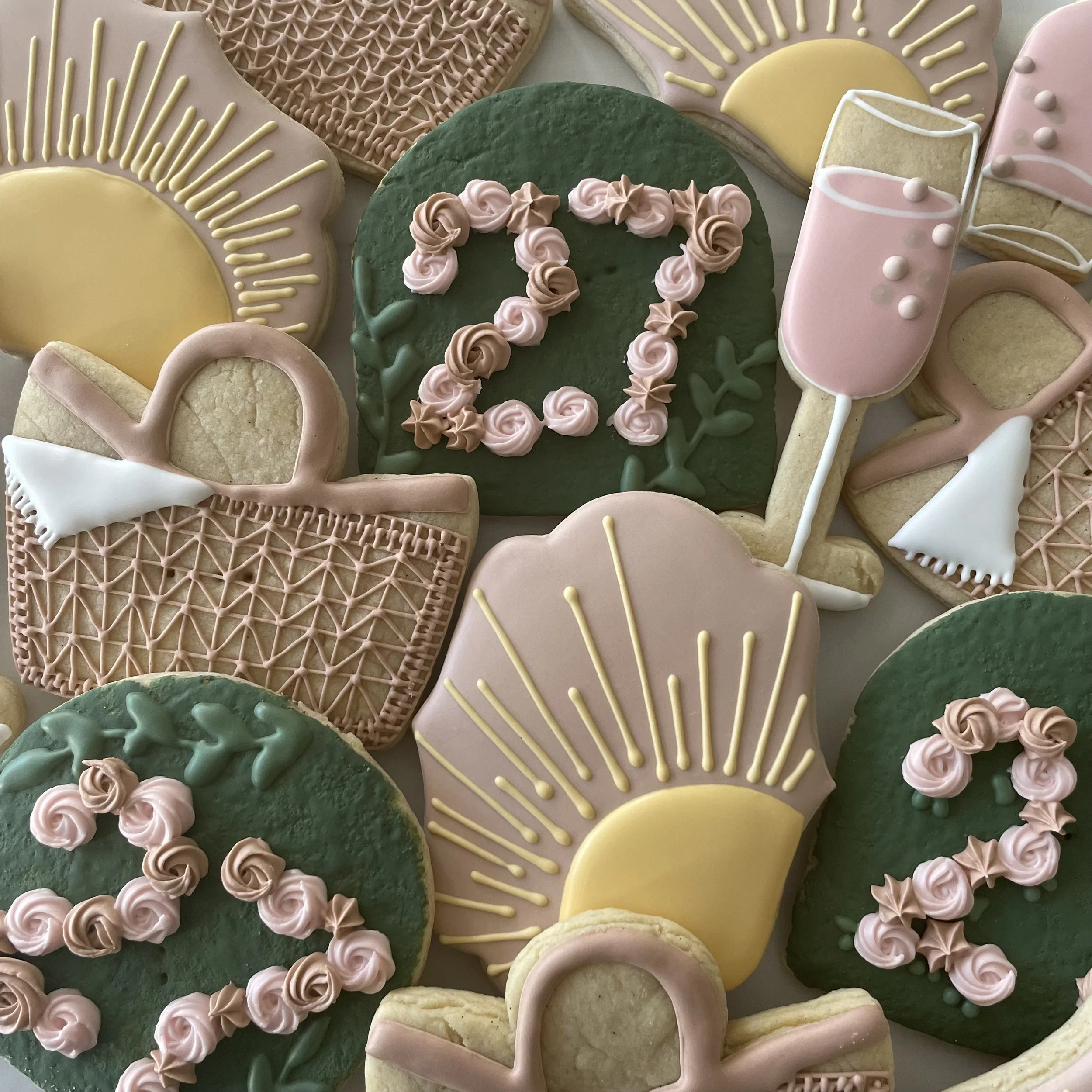 Decorative cookies with pastel pink, yellow, and green icing and various designs.