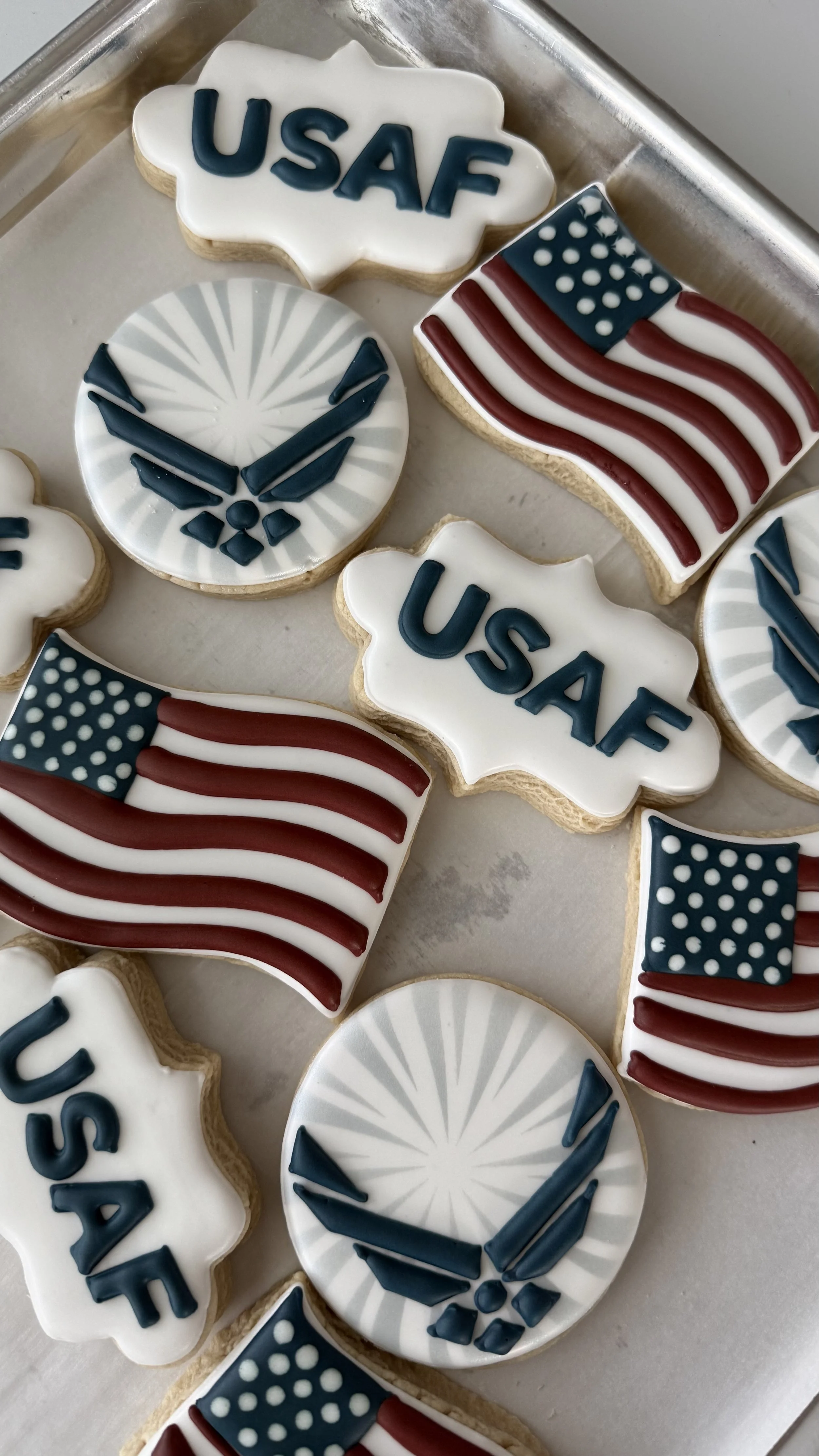 Decorated cookies with patriotic themes including U.S. flags, the word 'USA,' and military symbols.