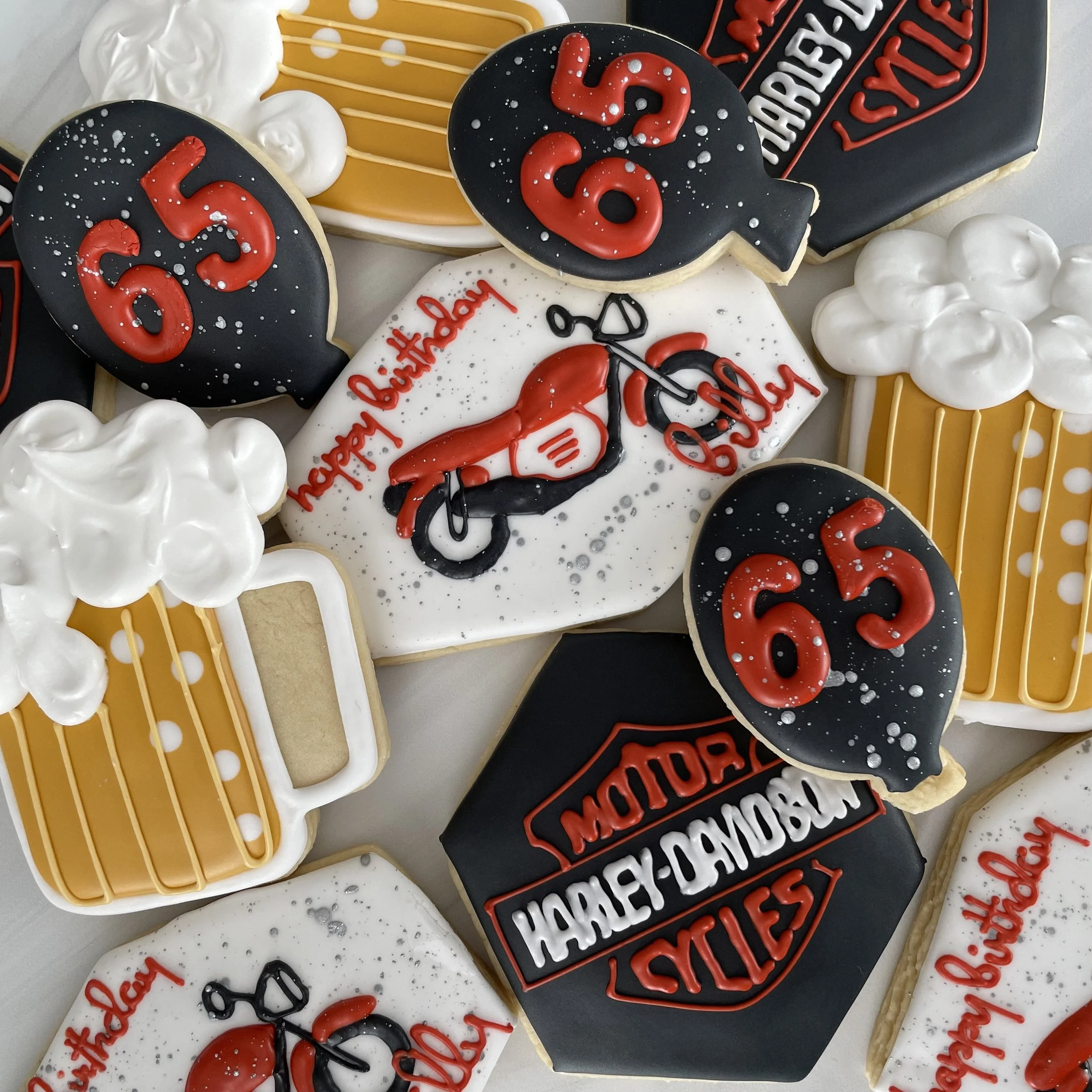 Assorted decorated cookies with birthday themes, including number '56' and 'Happy birthday' messages, in various shapes and colors, some with icing and sprinkles.