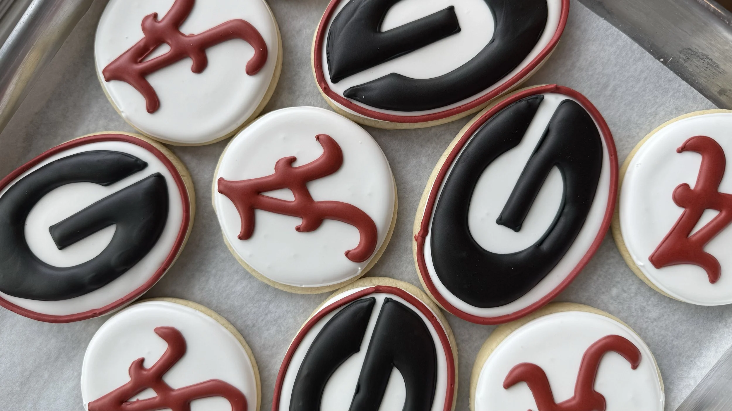Assorted cookies decorated with black, red, and white icing in the shape of the number 42.