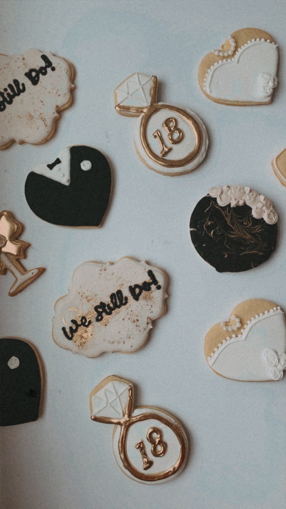Decorative cookies celebrating an 18th birthday, including a cookie with the number 18, a diamond ring, hearts, and messages like 'Cake all do!' arranged on a white surface.