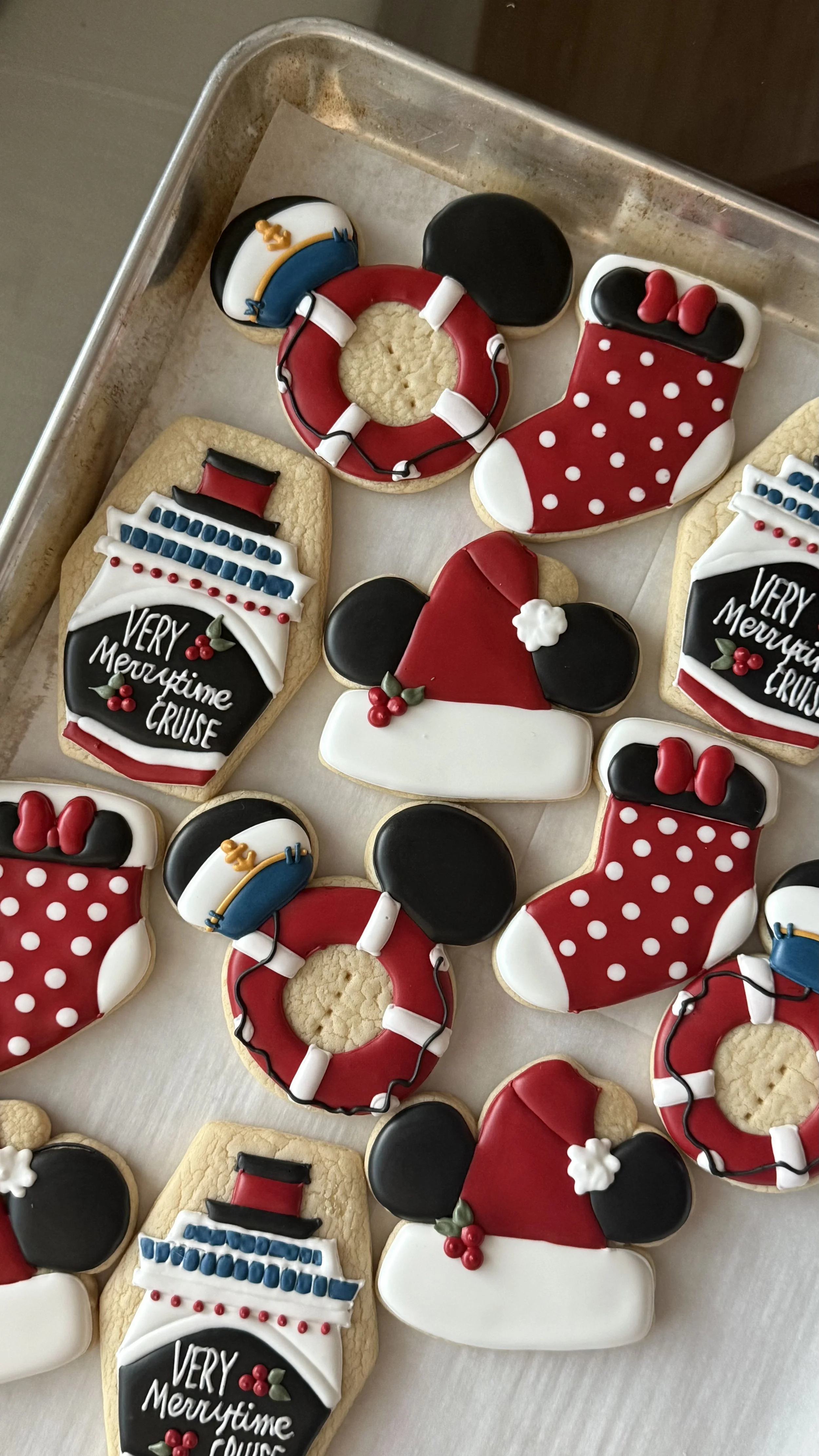 Cookies decorated with Christmas and cruise ship themes, including Mickey Mouse ears, life preservers, and boat designs.