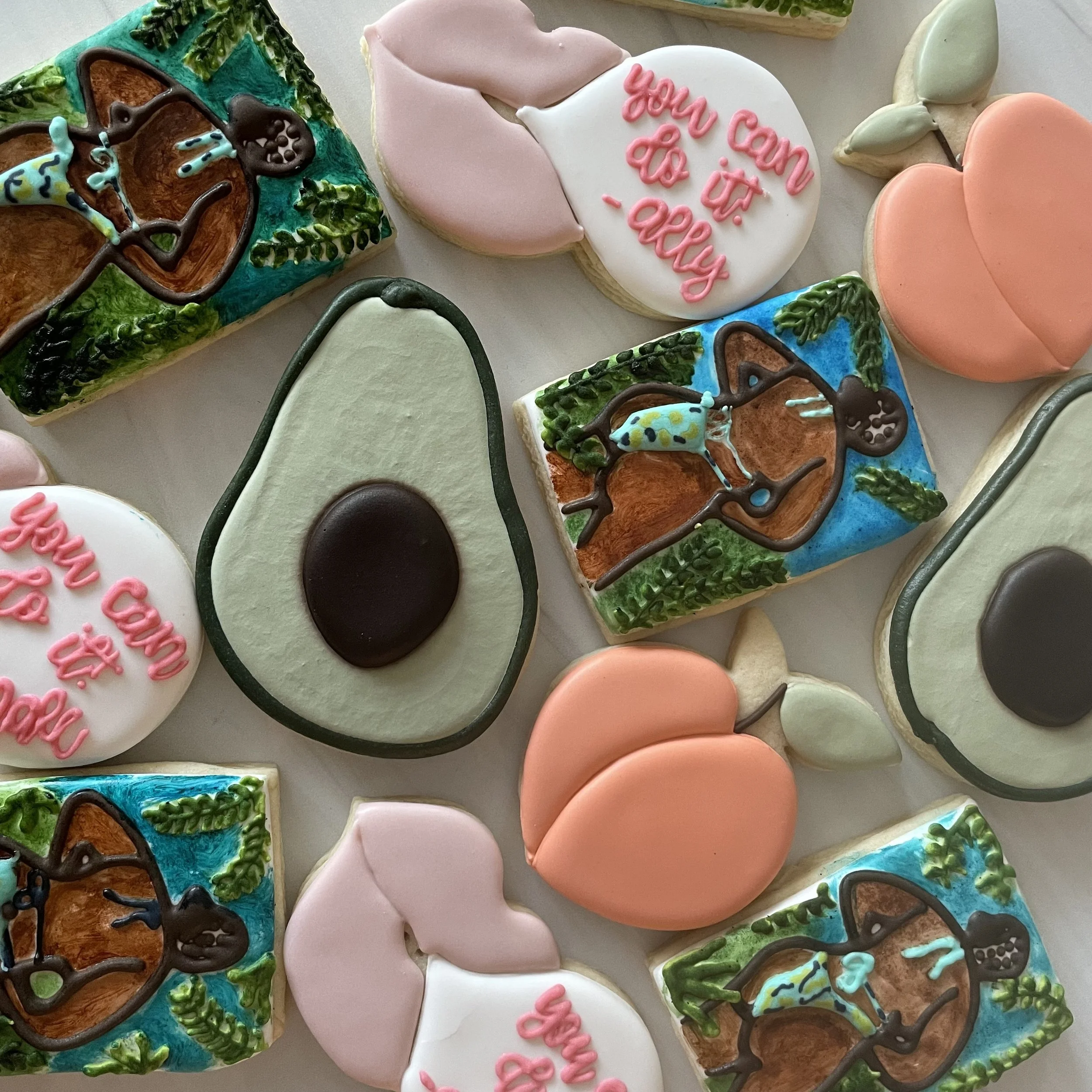 Assorted decorated cookies with various shapes, including a heart with a message, a cupcake, and a chocolate-dipped treat, all with colorful icing and decorations.