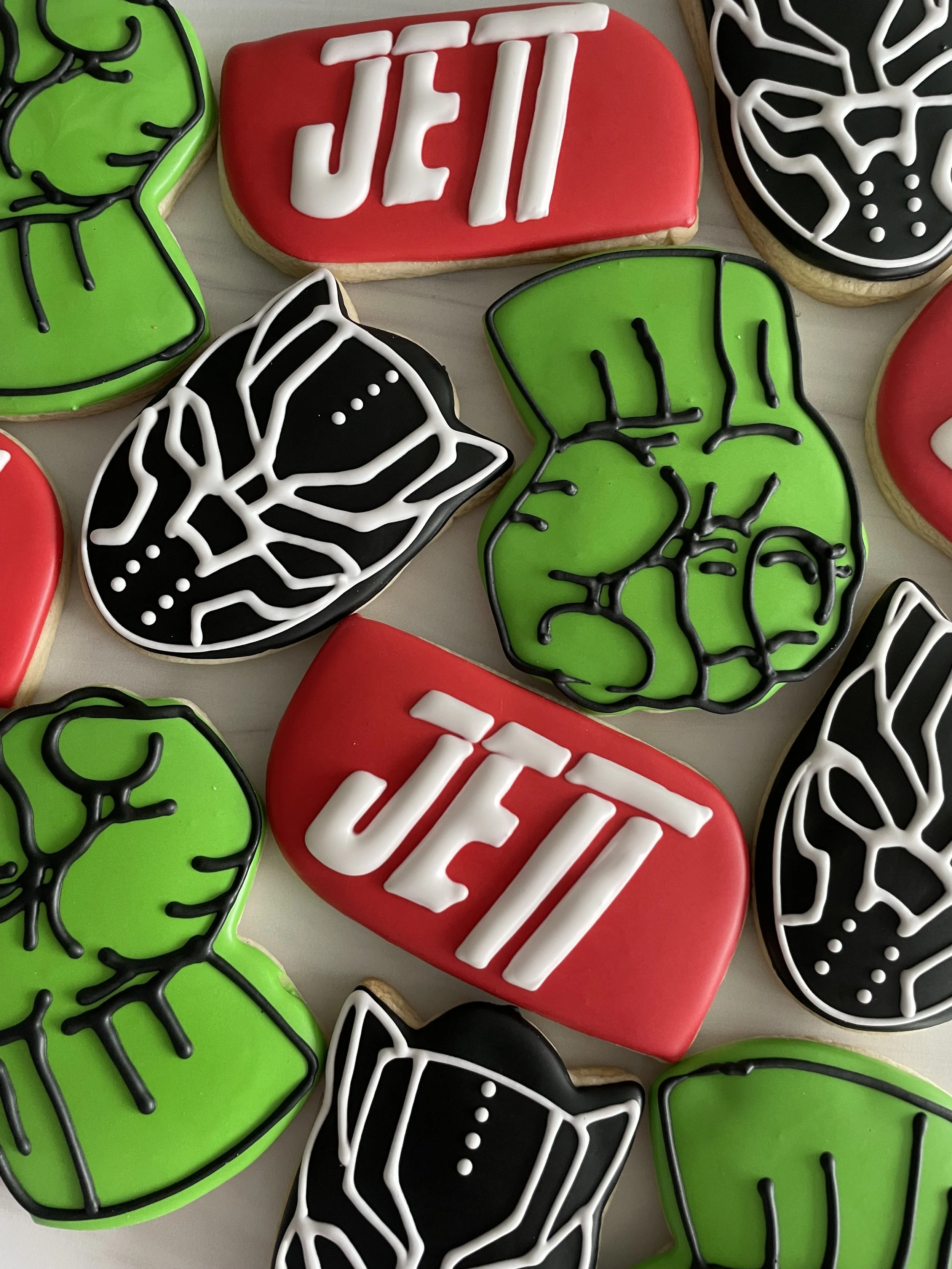 Decorated Halloween-themed cookies in Frankenstein, mummy, and 'Boo' designs with icing and colorful decorations.