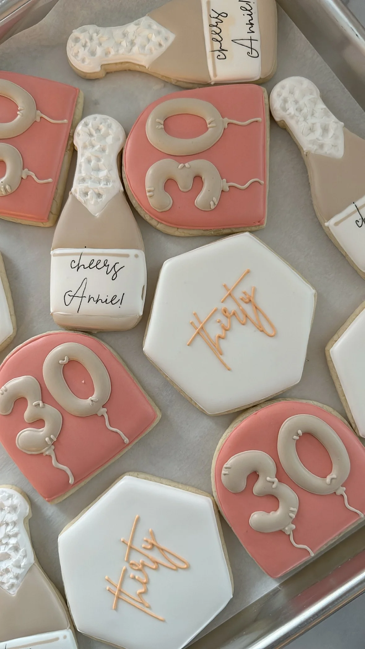 Decorated cookies with birthday messages and numbers. Some cookies have pink and white icing with 
