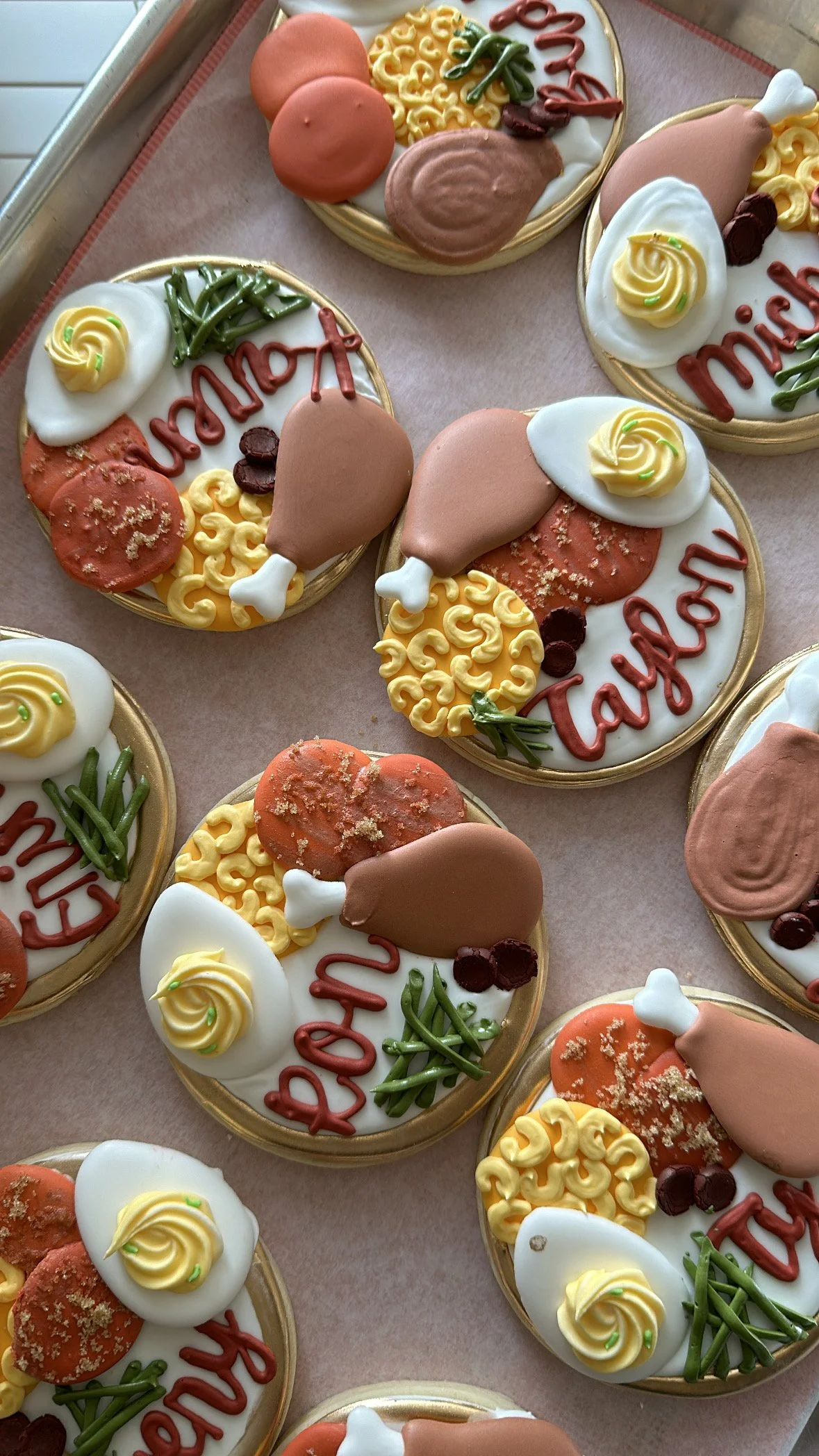 Decorated cookies with the words 'Happy Thanksgiving', turkey-shaped cookies, green sprinkles, small brown balls, and yellow ornate icing decorations.