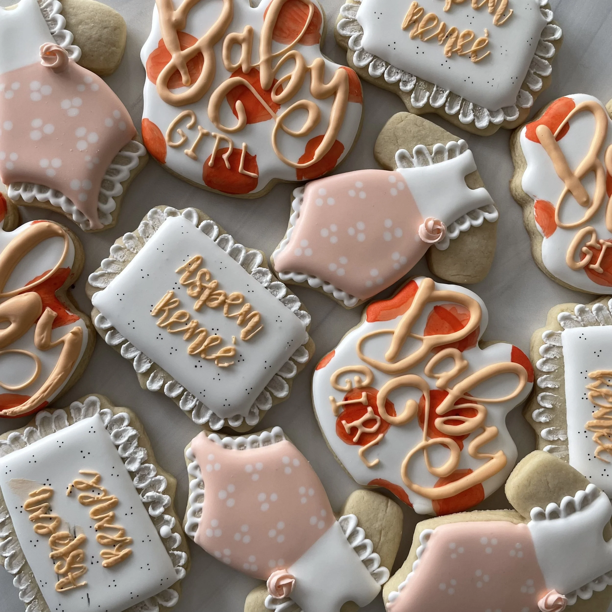 Assorted decorated cookies with messages like 'happy birthday' written in pink icing and various pink and white icing decorations.