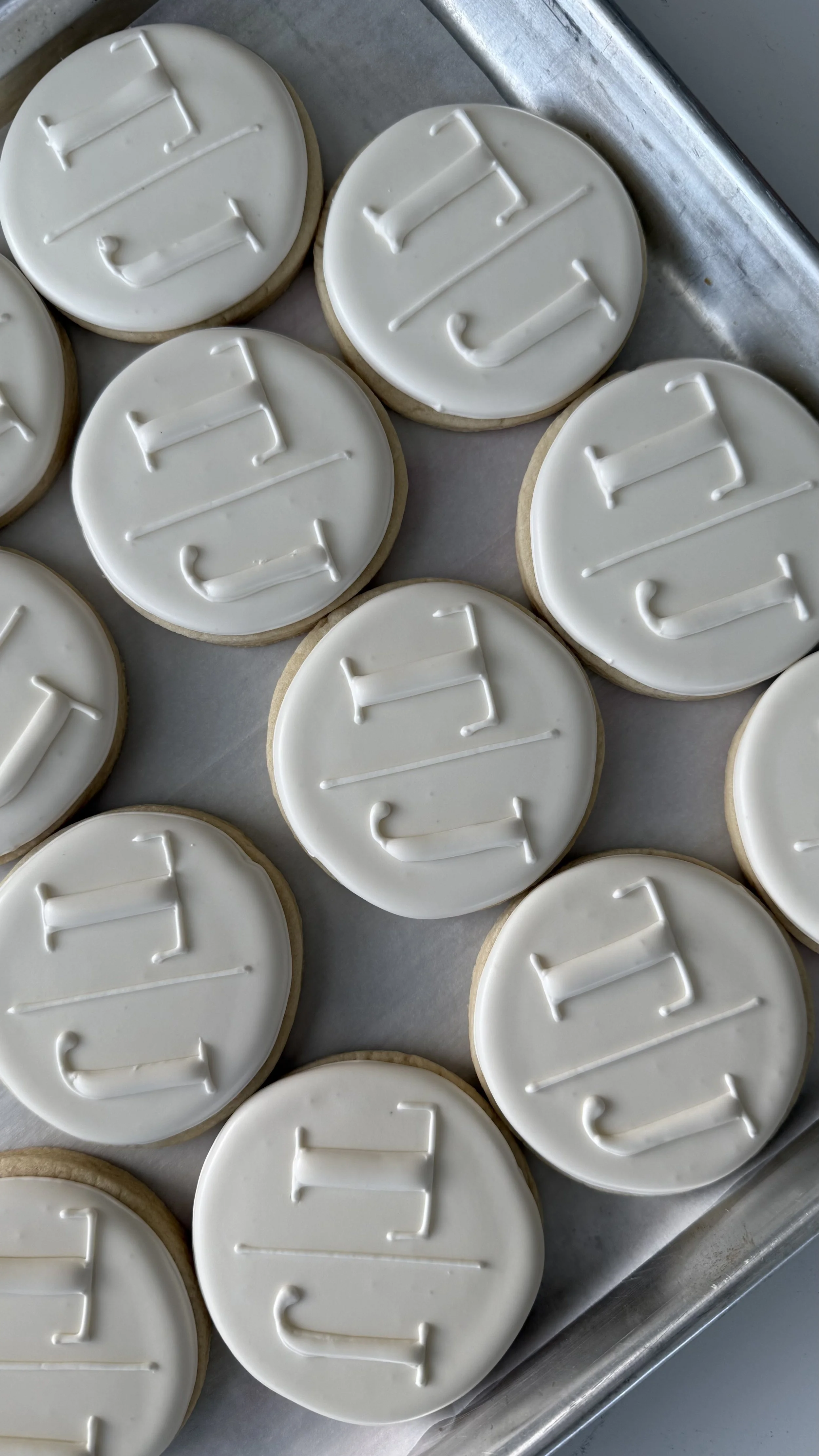 Cookies decorated with white icing, each with a letter, spelling out the word 'HELLO'.