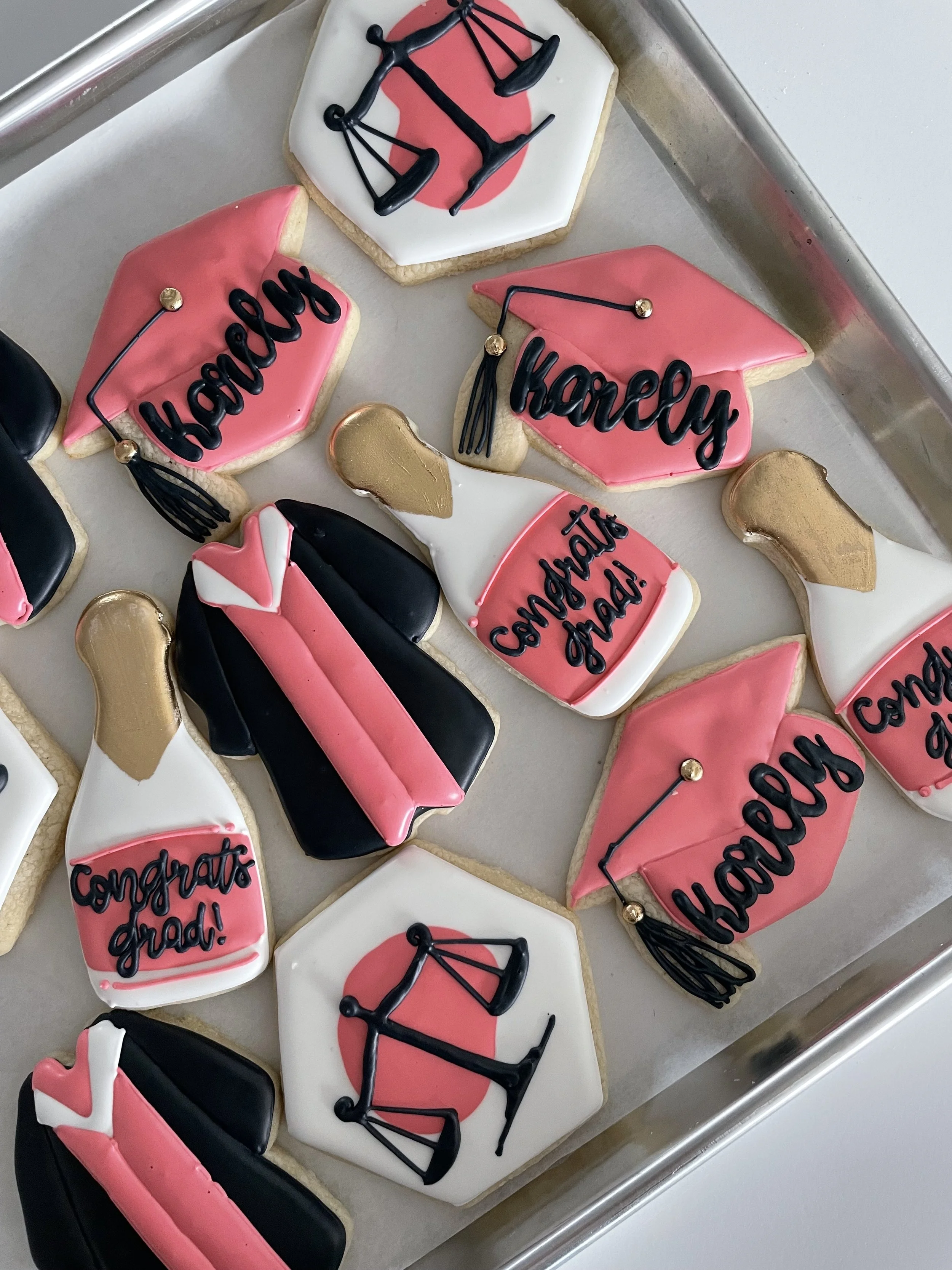 Decorated cookies with messages like 'congrats grad!' and 'way to go', and symbols such as a graduation cap and a diploma.