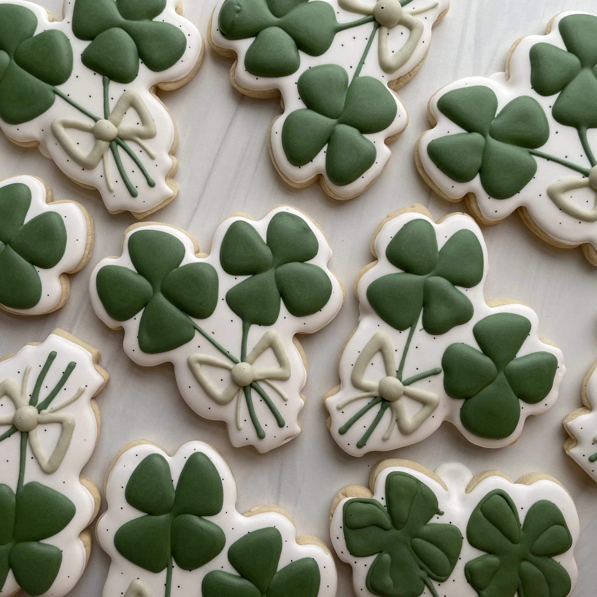 Cookies decorated with green shamrocks and white icing for St. Patrick's Day.