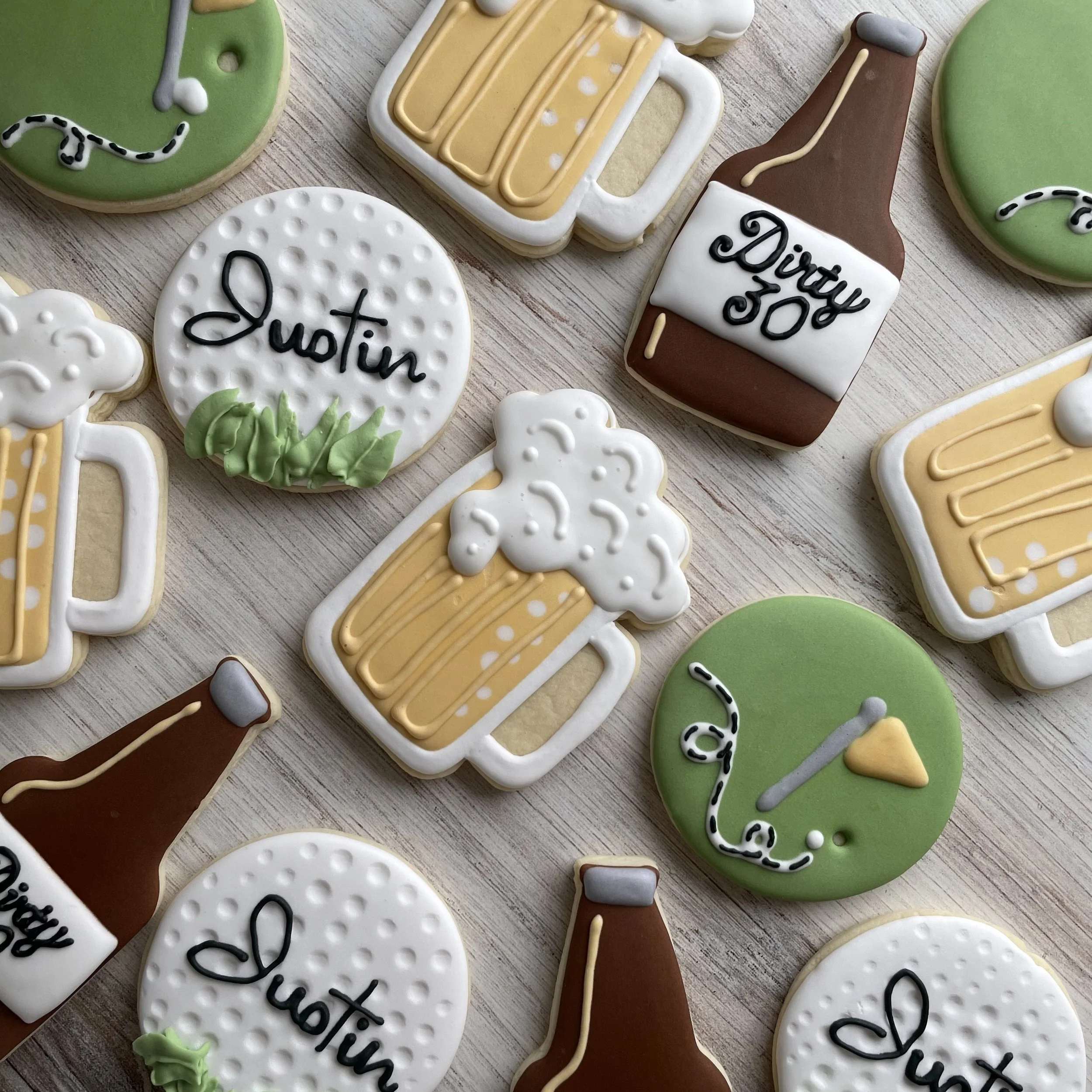 Decorated cookies for a birthday celebration, including cookies that say "Happy" and "Birthday 50th" with colorful icing and designs.