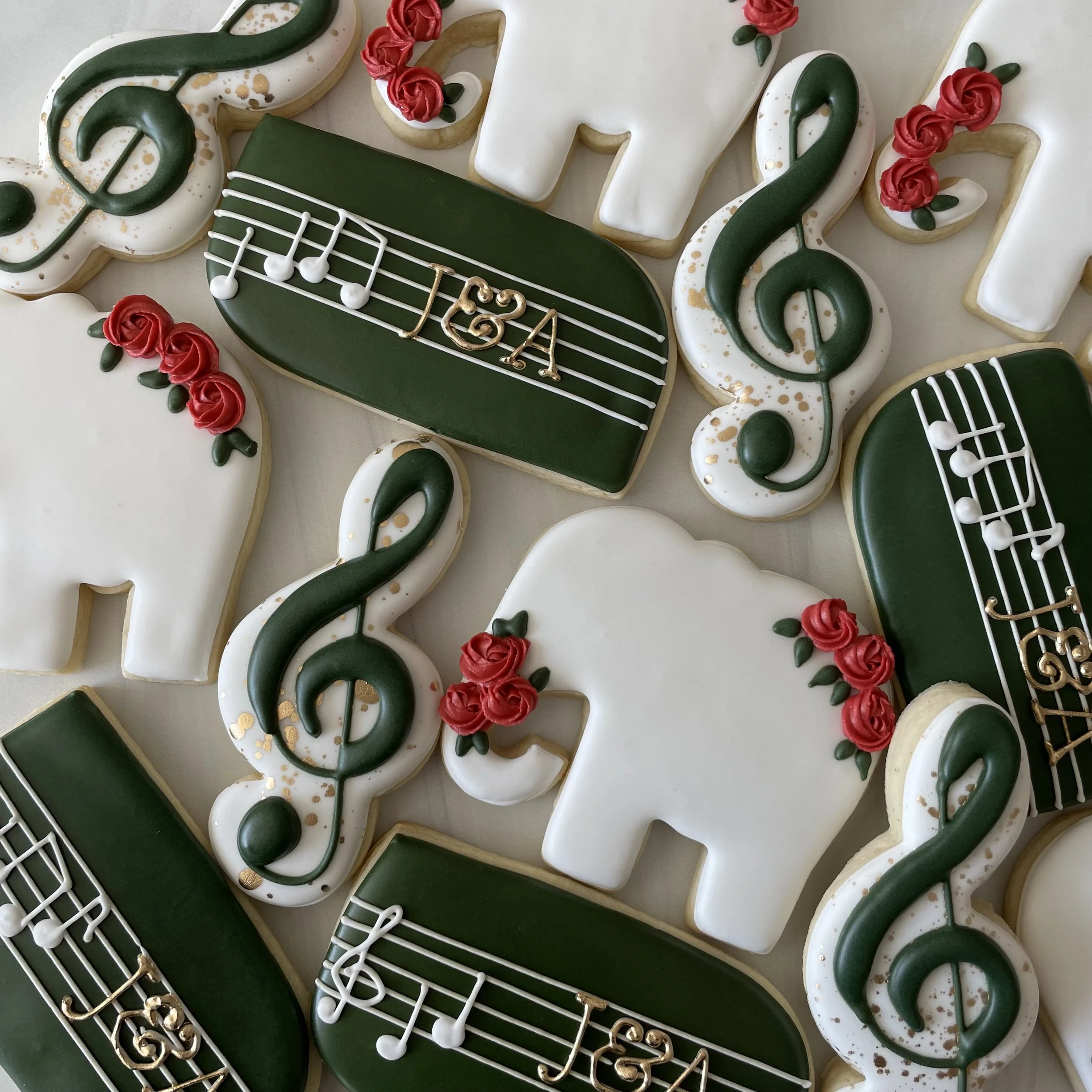 Decorated cookies with musical notes, a piano, and treble clef designs, all with white, green, red, and gold icing.